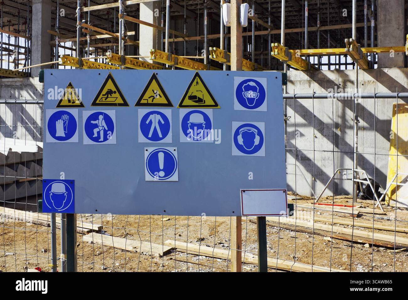Il piedistallo in metallo con lo standard di cartelli di avvertimento per la protezione del lavoro e della salute per la costruzione di Foto Stock