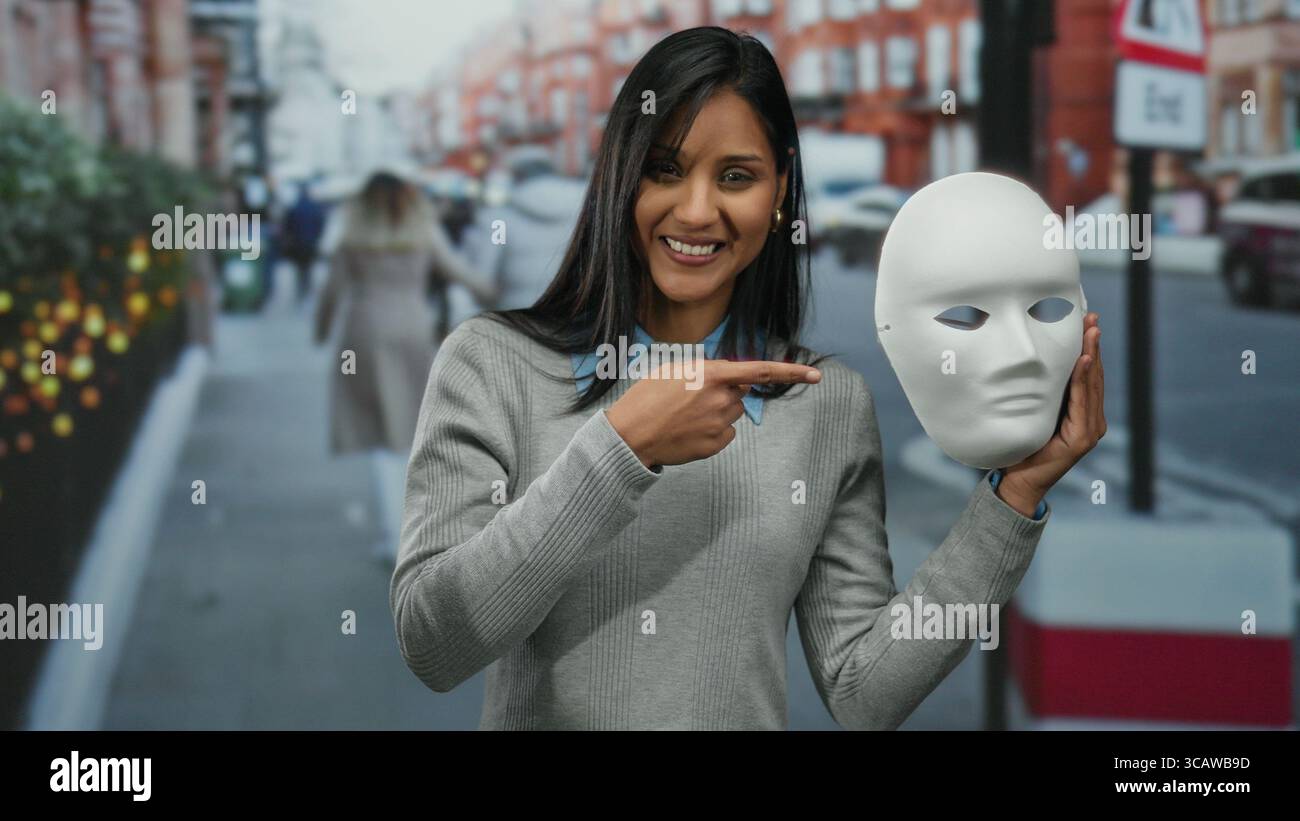 Donna sorridente ha una maschera bianca sullo sfondo urbano durante il giorno, mostrando mistero e intrighi nella vivace vita cittadina. Foto Stock