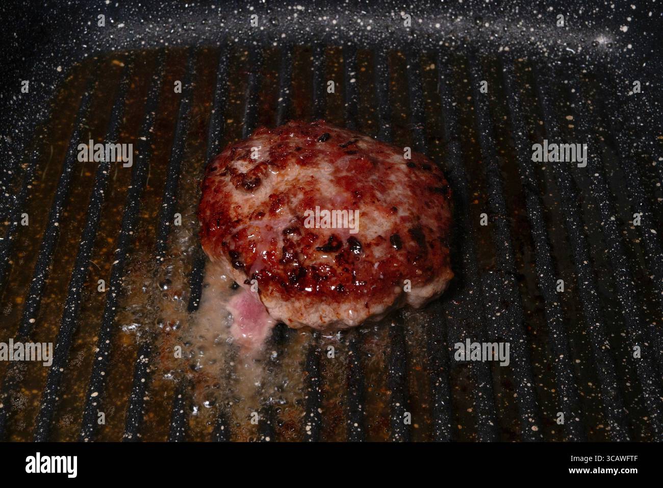 Deliziose polpette di hamburger sfrigolanti su una piastra, cucinando alla perfezione Foto Stock