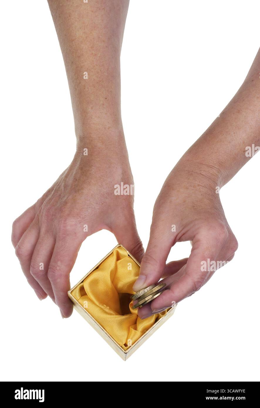 La persona anziana e risparmia fino agli ultimi soldi per il concetto di pensione. Isolate le mani e la cassetta della carta studio shot Foto Stock