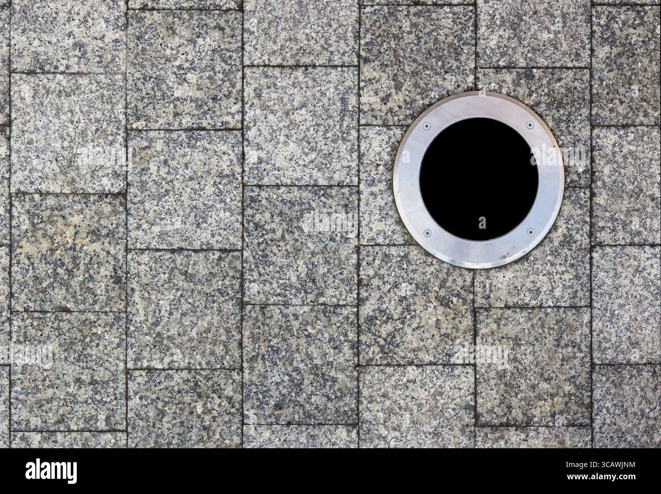 La pavimentazione della città è rivestita da piastrelle quadrate in marmo. La lampada rotonda è montata sulla superficie della strada Foto Stock