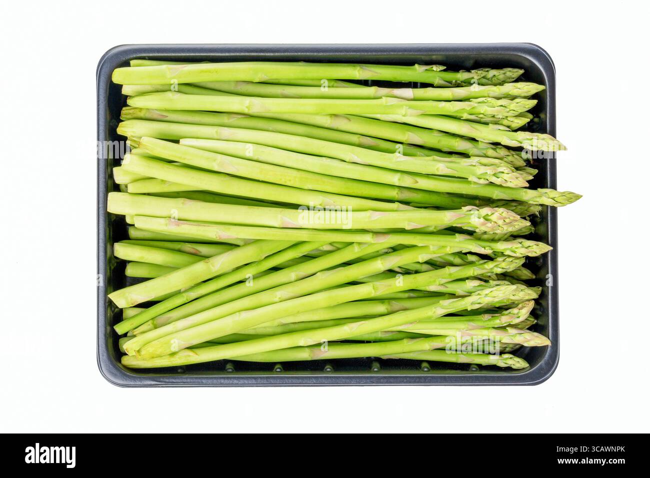 Germogli freschi di asparagi verdi in una scatola isolata su sfondo bianco. Primo piano. Foto Stock