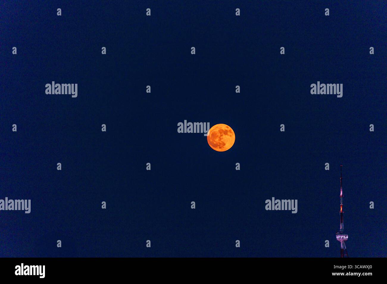 La Luna delle fragole si innalza sopra Tbilisi, capitale della Georgia Foto Stock