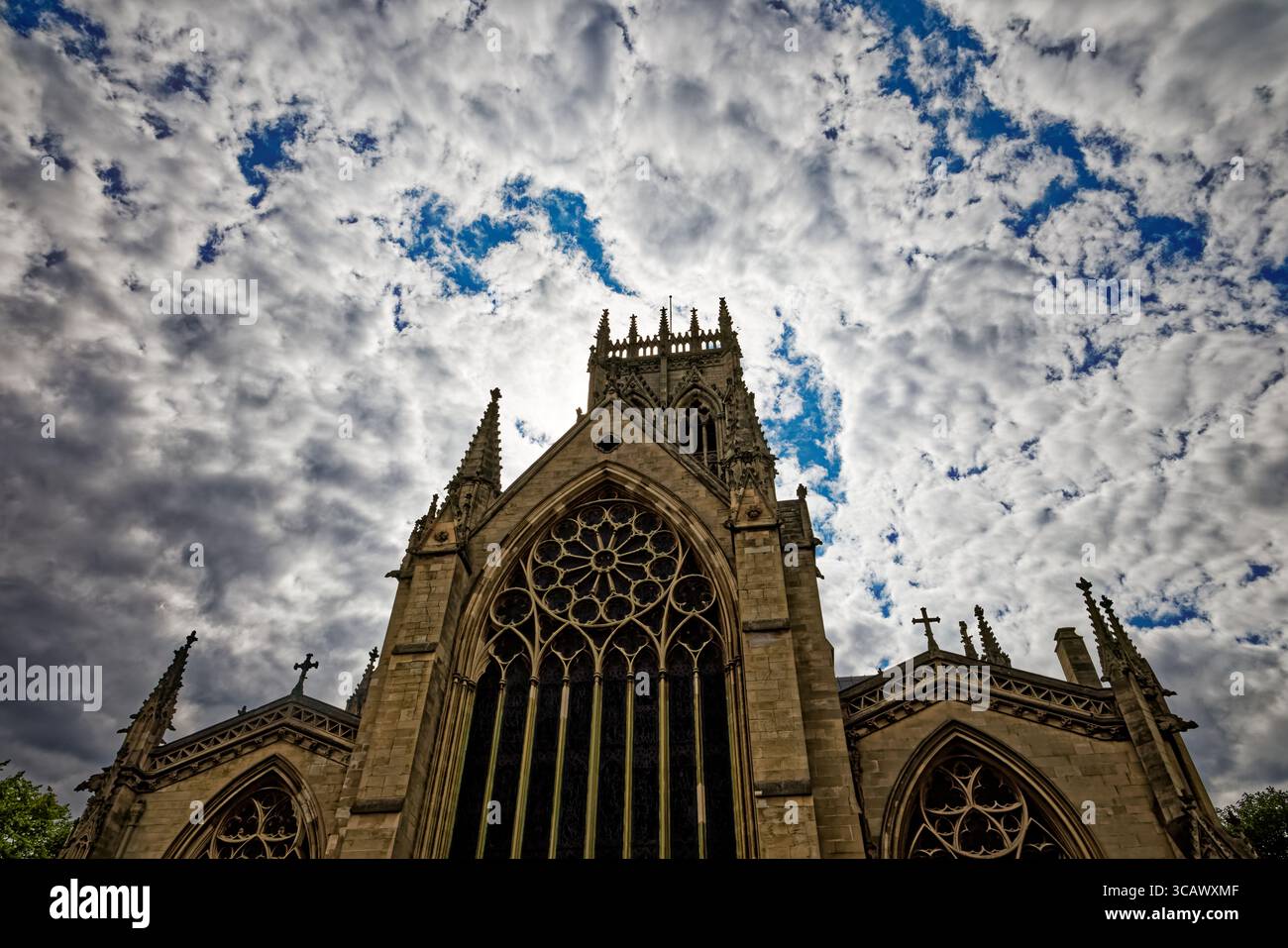 La grande finestra est e la torre di Doncaster Minster si innalzano in un suggestivo cielo blu e bianco, South Yorkshire, Inghilterra. Foto Stock