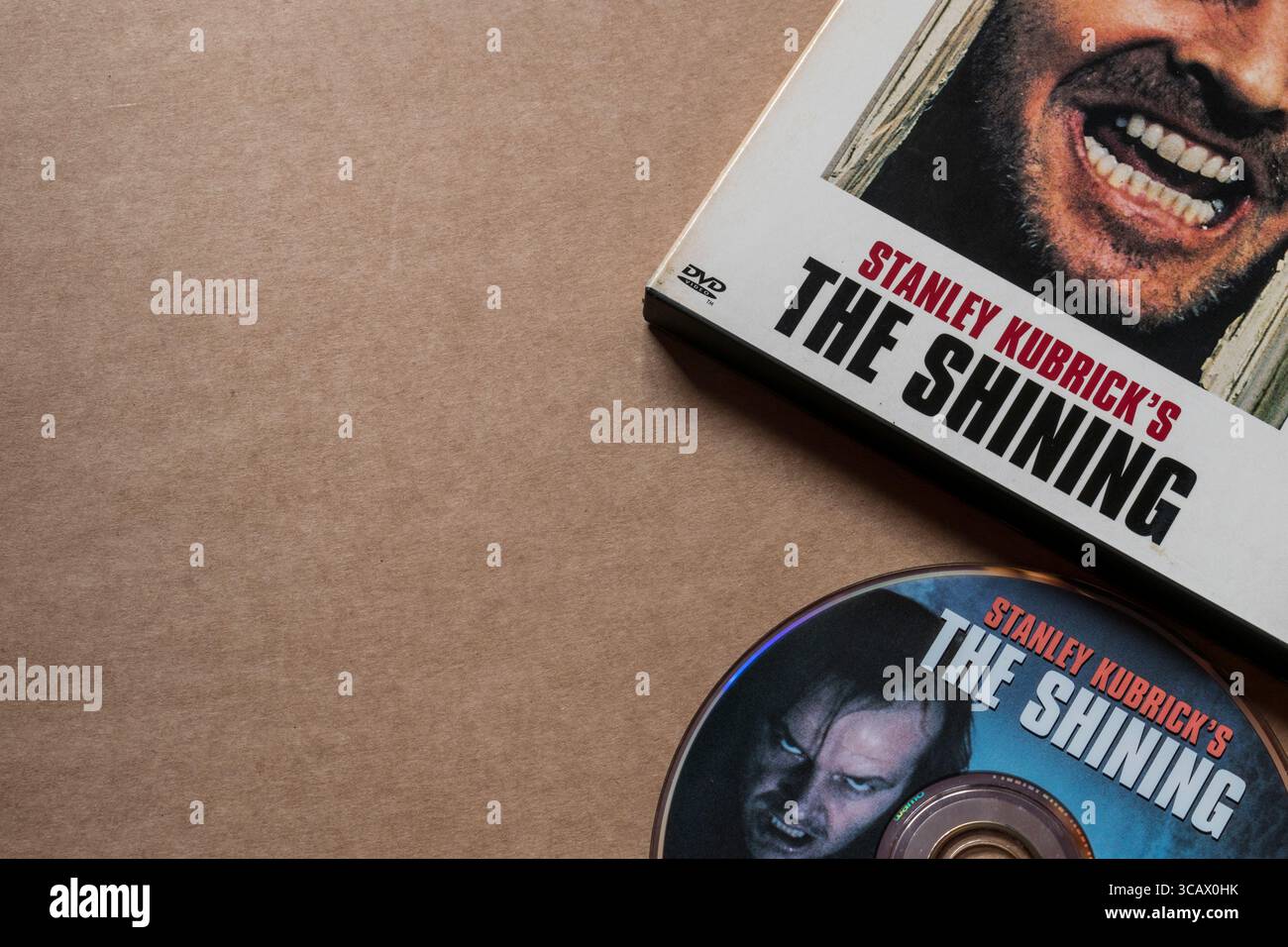 Il disco DVD Shining con coperchio del box per film, isolato su sfondo bianco chiaro Foto Stock