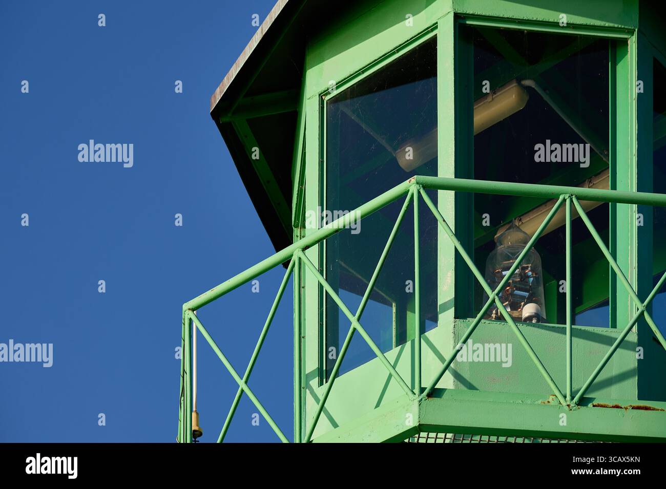 Vista ravvicinata del balcone e delle finestre di un faro verde luminoso alla luce del sole. Foto Stock
