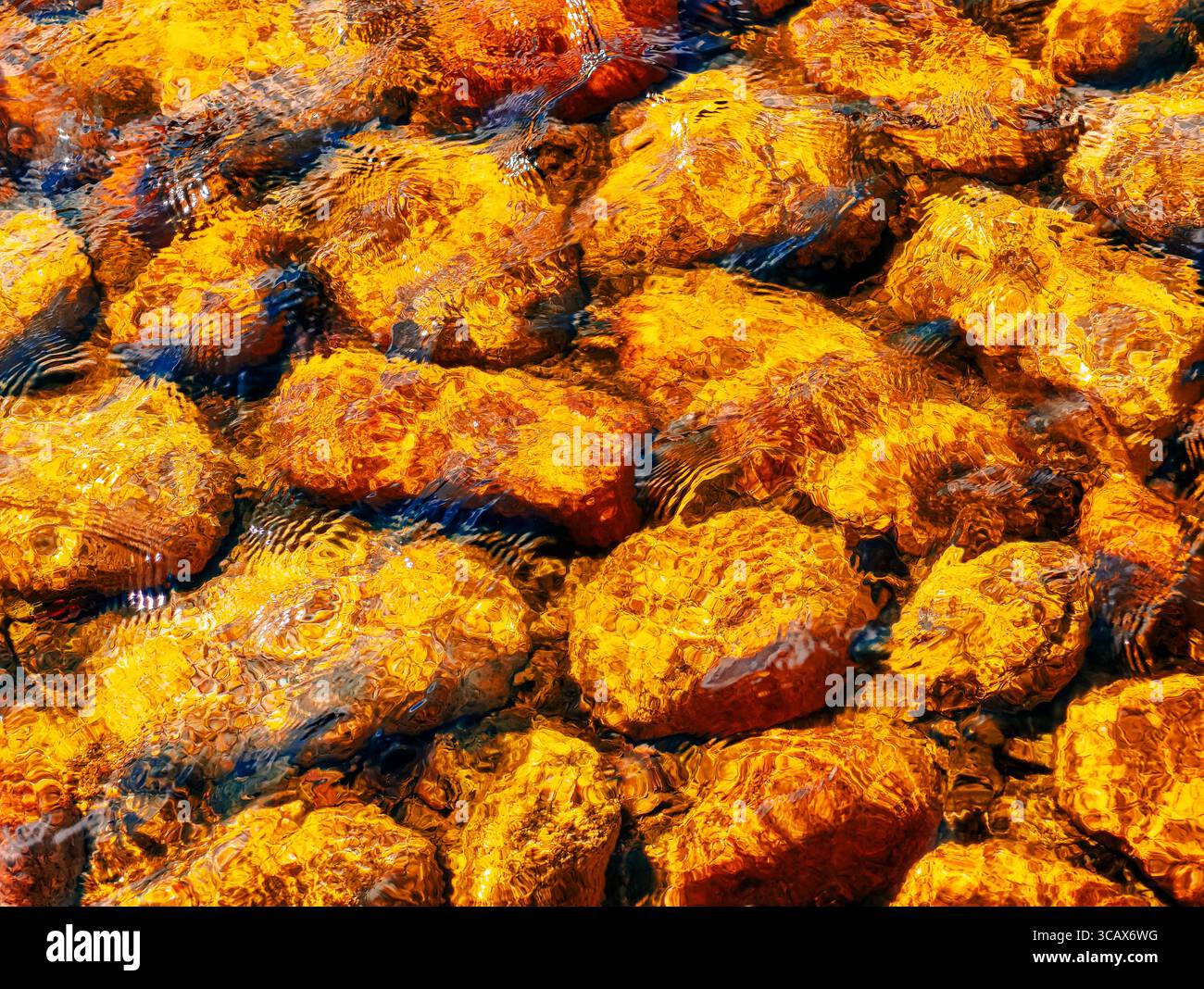 Scintillanti pietre color ambra sott'acqua. Immagine ad alta risoluzione perfetta per sfondi, marketing digitale, progetti creativi e straordinari display visivi Foto Stock