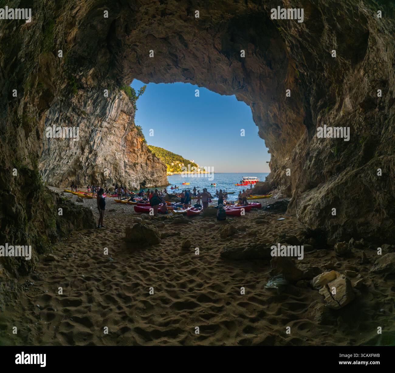 Dubrovnik, Croazia - 12 settembre 2023: I kayak si riuniscono su una spiaggia durante un tour al tramonto, preparandosi a lanciarsi nel mare Adriatico. Foto Stock