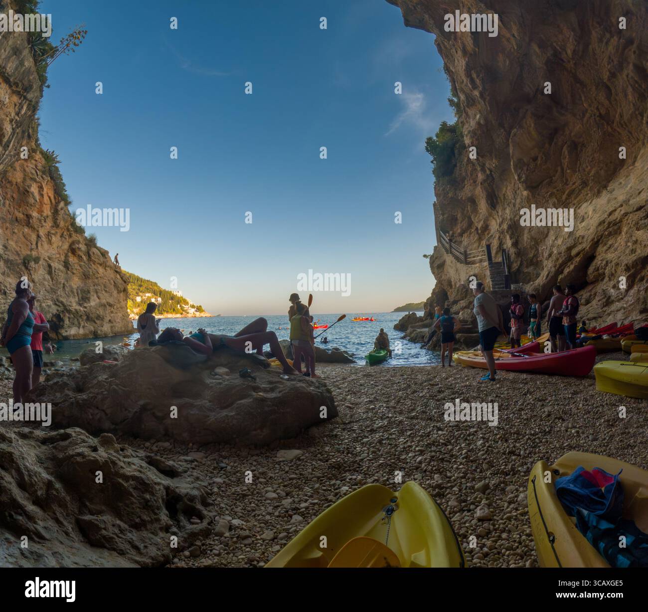 Dubrovnik, Croazia - 12 settembre 2023: Le persone si rilassano e si preparano per un tour in kayak al tramonto, esplorando la costa e le grotte vicino Dubrovnik. Foto Stock