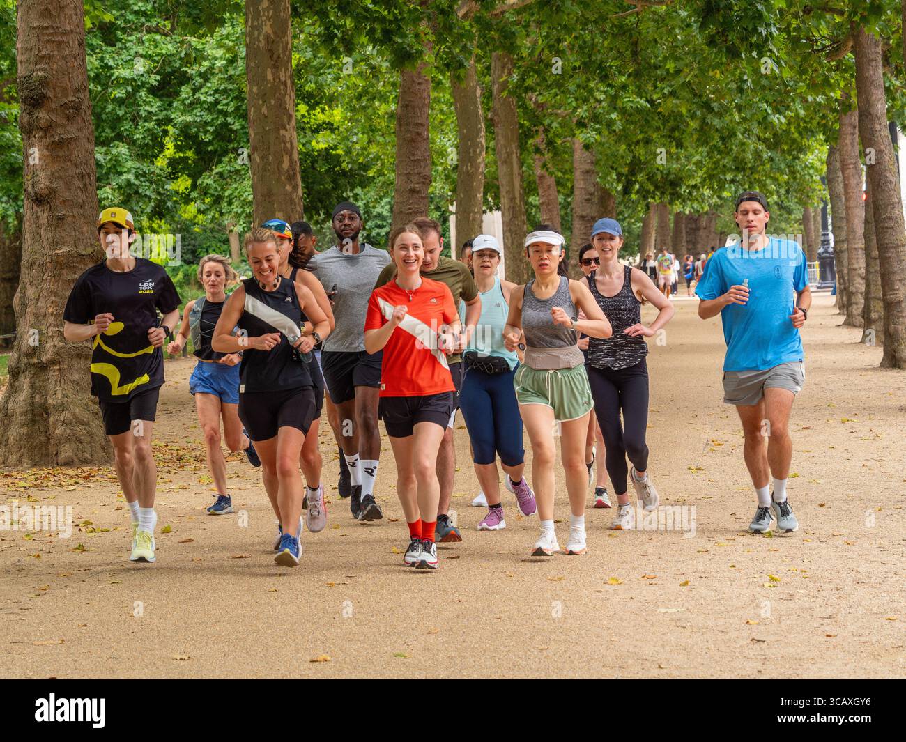 Un gruppo diversificato di persone che corrono insieme per il fitness e il tempo libero sui sentieri del St James's Park a Londra, Regno Unito. Foto Stock