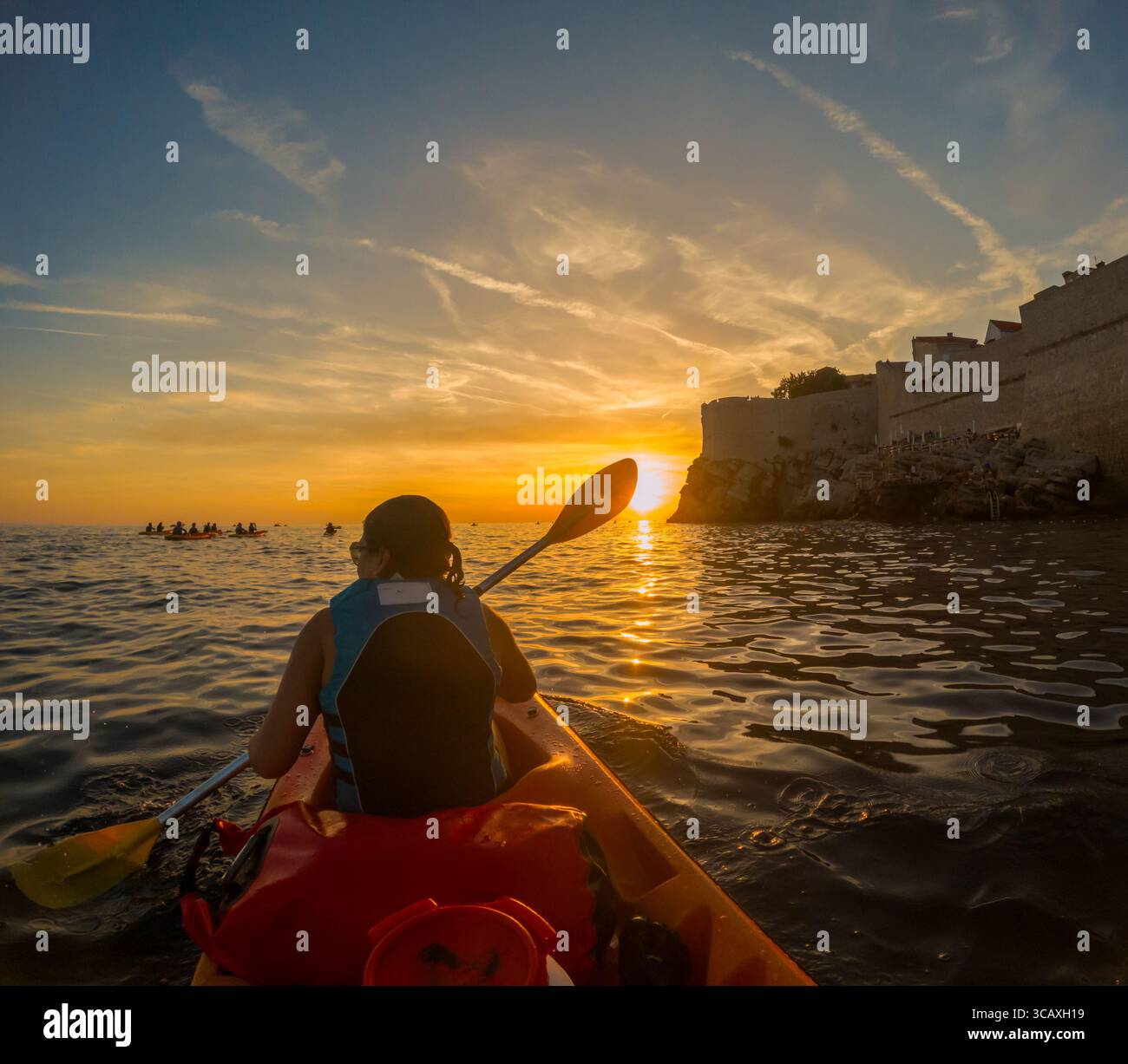 Dubrovnik, Croazia - 12 settembre 2023: Un kayak si dirige verso il tramonto durante un tour guidato lungo le storiche mura della città, godendosi la vista Foto Stock