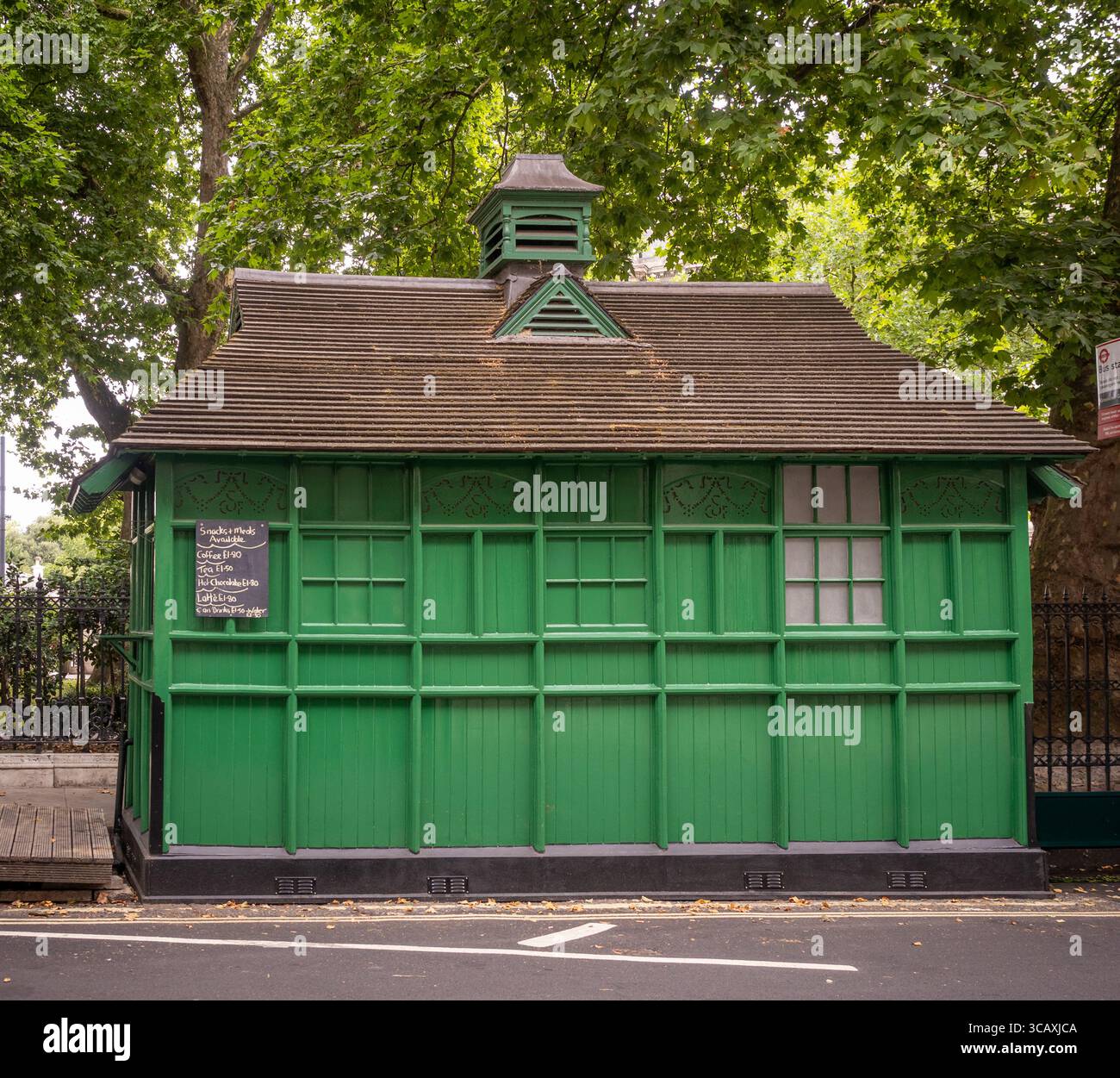 Uno storico Cabman's Shelter, classificato di secondo livello, una piccola capanna di legno verde originariamente per i tassisti, a Grosvenor Gardens, Londra, Regno Unito. Foto Stock