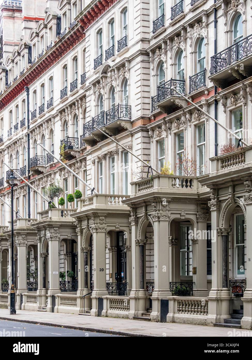 Una grande terrazza di case vittoriane ornate con imponenti portici colonnati, tipici dei quartieri residenziali di Londra, Regno Unito. Foto Stock