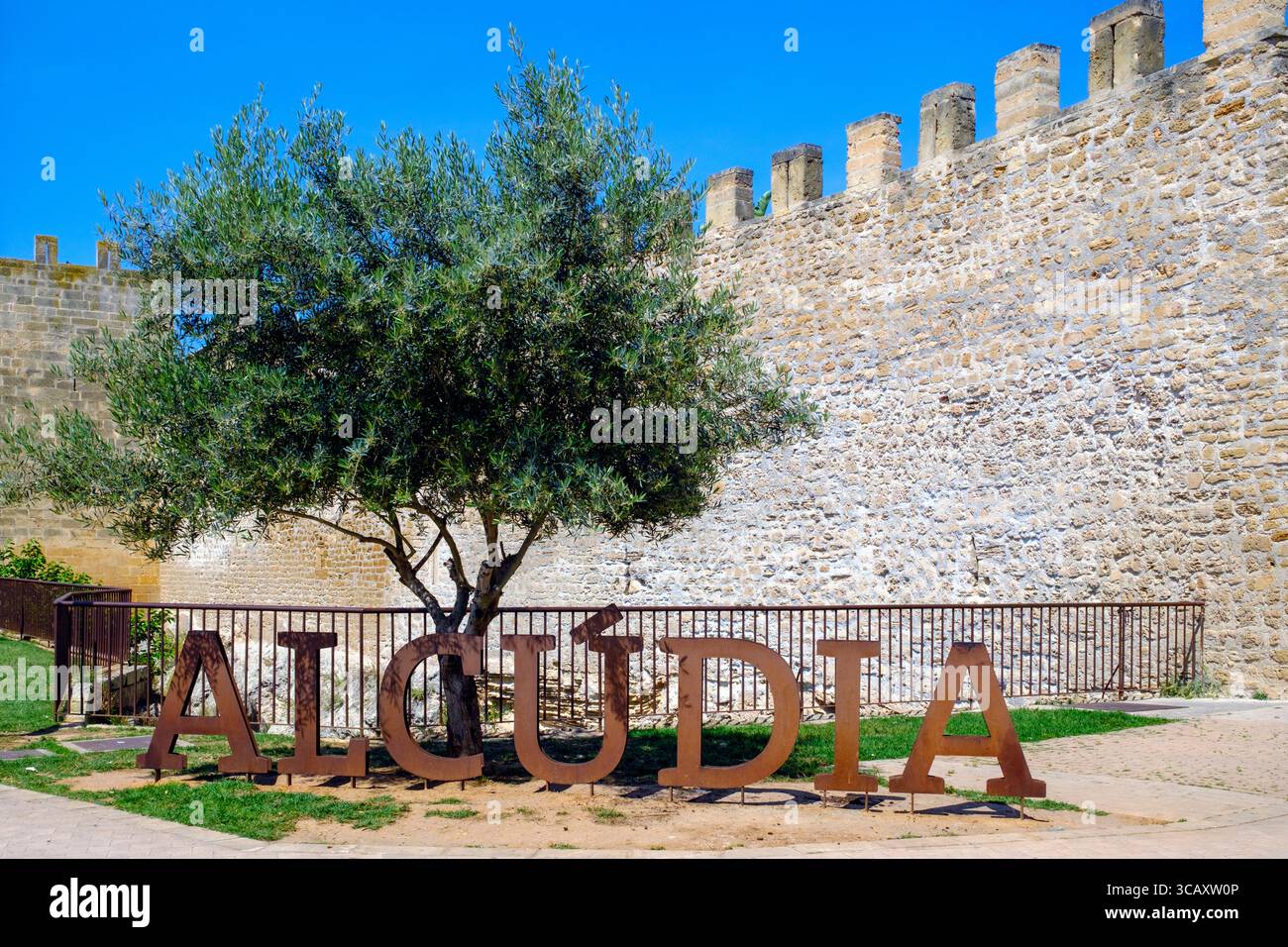 Muro della città vecchia di Alcudia, Maiorca, Spagna, con un cartello con la scritta "ALCUDIA" in grandi lettere. Foto Stock