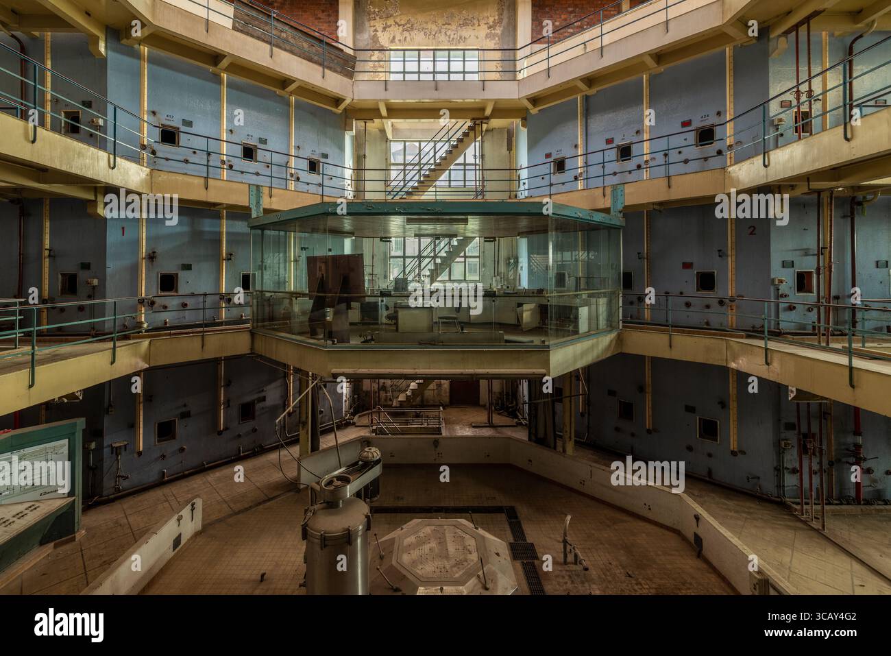 Sala di controllo industriale ottagonale abbandonata con ufficio in vetro e scale a più livelli in una cantina francese abbandonata Foto Stock