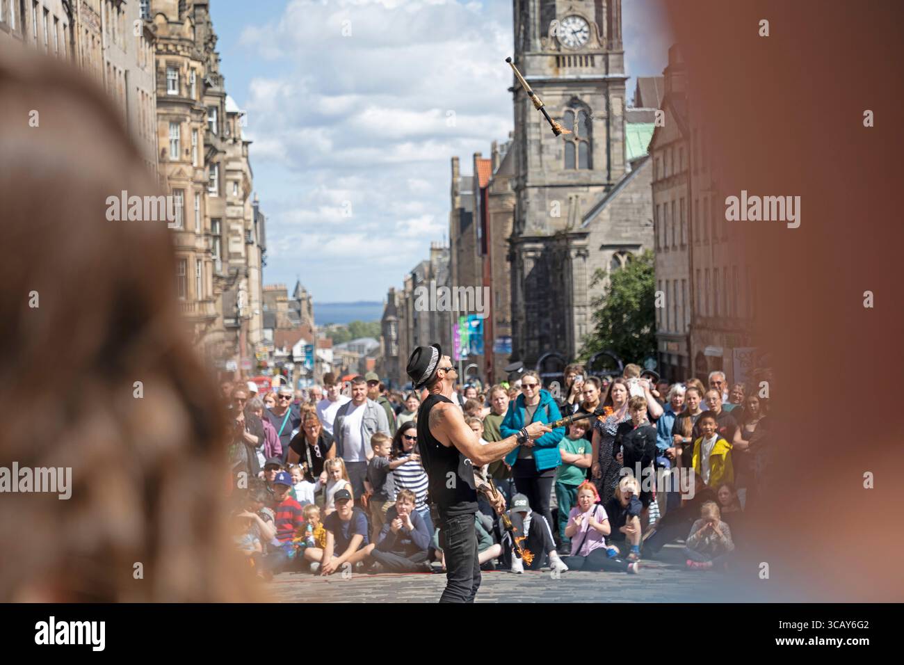 Edinburgh Festival Fringe, Royal Mile, Edimburgo, Scozia, Regno Unito. 7 agosto 2025. Giornata soleggiata e nuvolosa per gli artisti di High Street, attirando ancora una grande folla per le loro esibizioni. Nella foto, Paul Kllass si destreggia con le torce di fuoco. Credito: Arch White/alamy notizie dal vivo Foto Stock