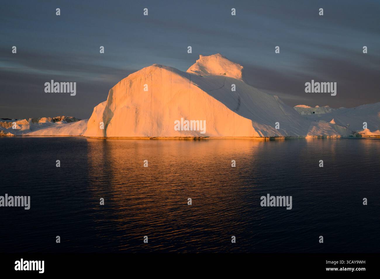 Enorme iceberg nella calda luce del sole di mezzanotte vicino a Ilulissat, in Groenlandia Foto Stock