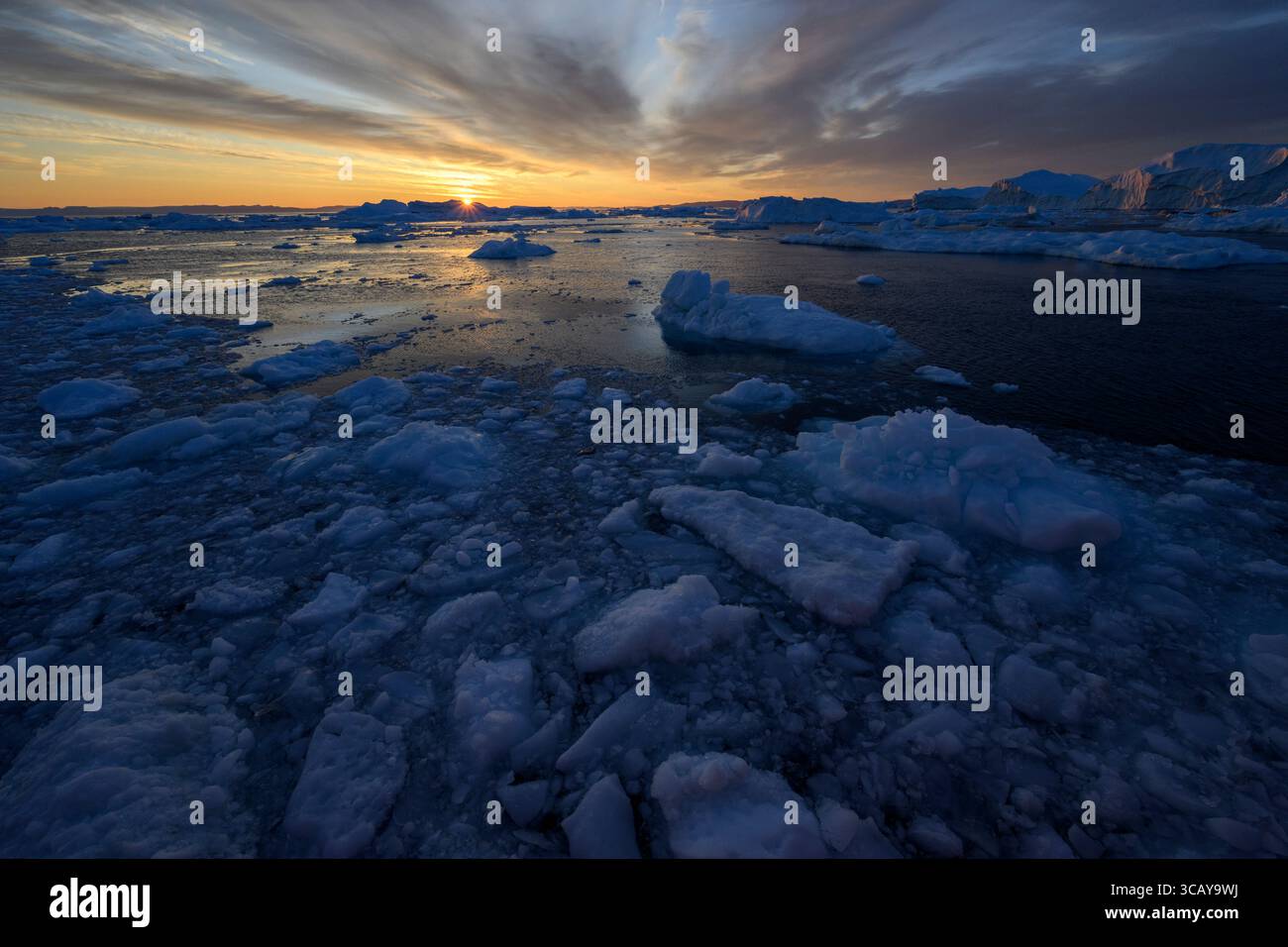 Alla deriva ghiaccio e iceberg durante il sole di mezzanotte vicino a Ilulissat, in Groenlandia Foto Stock