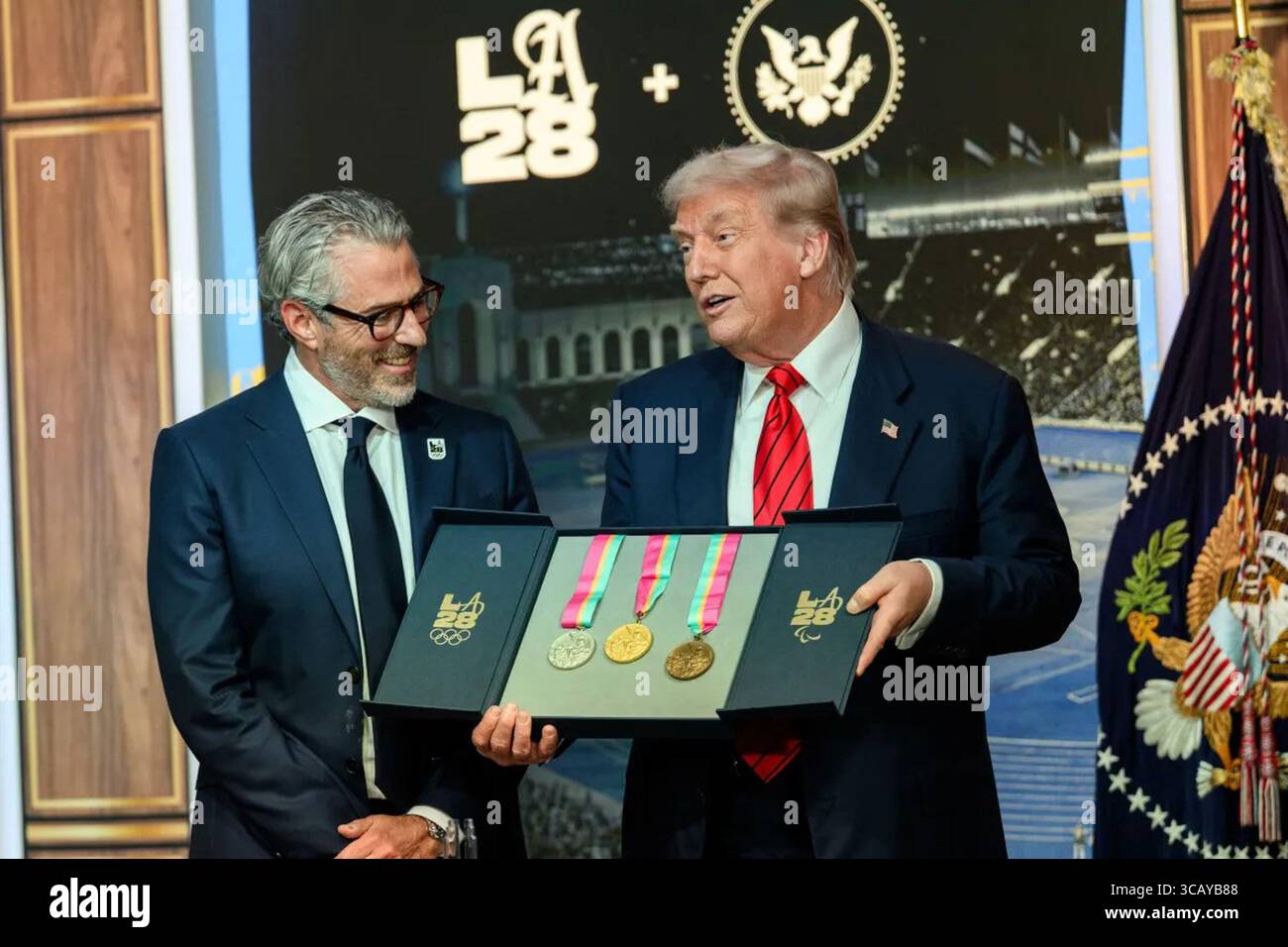 Il presidente Donald J. Trump detiene una scatola commemorativa con le medaglie d'oro, d'argento e di bronzo per i Giochi Olimpici e Paralimpici di Los Angeles 2028 durante una cerimonia all'Andrew W. Mellon Auditorium di Washington, D.C., il 5 agosto 2025. Trump ha ricevuto le medaglie come parte del lancio della Task Force della Casa Bianca per LA28. Per gentile concessione della Casa Bianca. Foto Stock