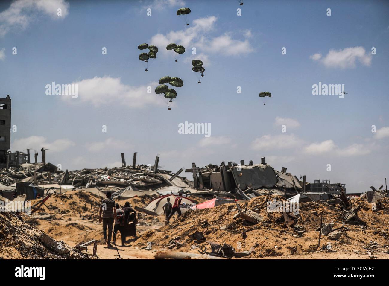 Gaza, Gaza. 7 agosto 2025. Gli aerei rilasciano aiuti con paracadute in mezzo agli attacchi israeliani, mentre i palestinesi si radunano nella zona in cui gli aiuti umanitari atterrano in cima alle case distrutte nella parte occidentale di Gaza, Gaza, giovedì 7 agosto 2025. Foto di Mahmoud Issa/UPI credito: UPI/Alamy Live News Foto Stock Gaza, Gaza. 7 agosto 2025. Gli aerei rilasciano aiuti con paracadute in mezzo agli attacchi israeliani, mentre i palestinesi si radunano nella zona in cui gli aiuti umanitari atterrano in cima alle case distrutte nella parte occidentale di Gaza, Gaza, giovedì 7 agosto 2025. Foto di Mahmoud Issa/UPI credito: UPI/Alamy Live News Foto Stock