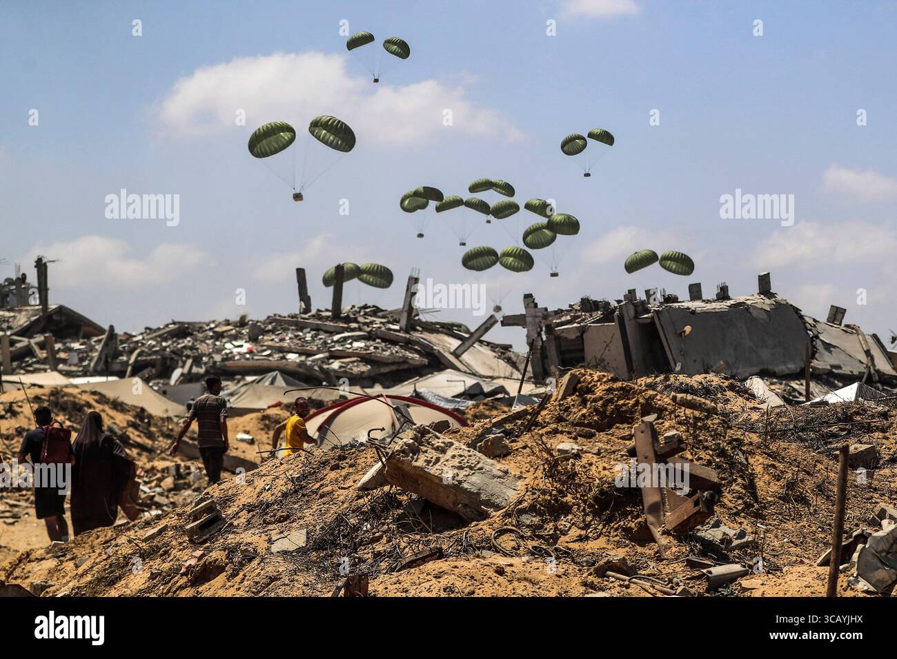 Gaza, Gaza. 7 agosto 2025. Gli aerei rilasciano aiuti con paracadute in mezzo agli attacchi israeliani, mentre i palestinesi si radunano nella zona in cui gli aiuti umanitari atterrano in cima alle case distrutte nella parte occidentale di Gaza, Gaza, giovedì 7 agosto 2025. Foto di Mahmoud Issa/UPI credito: UPI/Alamy Live News Foto Stock Gaza, Gaza. 7 agosto 2025. Gli aerei rilasciano aiuti con paracadute in mezzo agli attacchi israeliani, mentre i palestinesi si radunano nella zona in cui gli aiuti umanitari atterrano in cima alle case distrutte nella parte occidentale di Gaza, Gaza, giovedì 7 agosto 2025. Foto di Mahmoud Issa/UPI credito: UPI/Alamy Live News Foto Stock