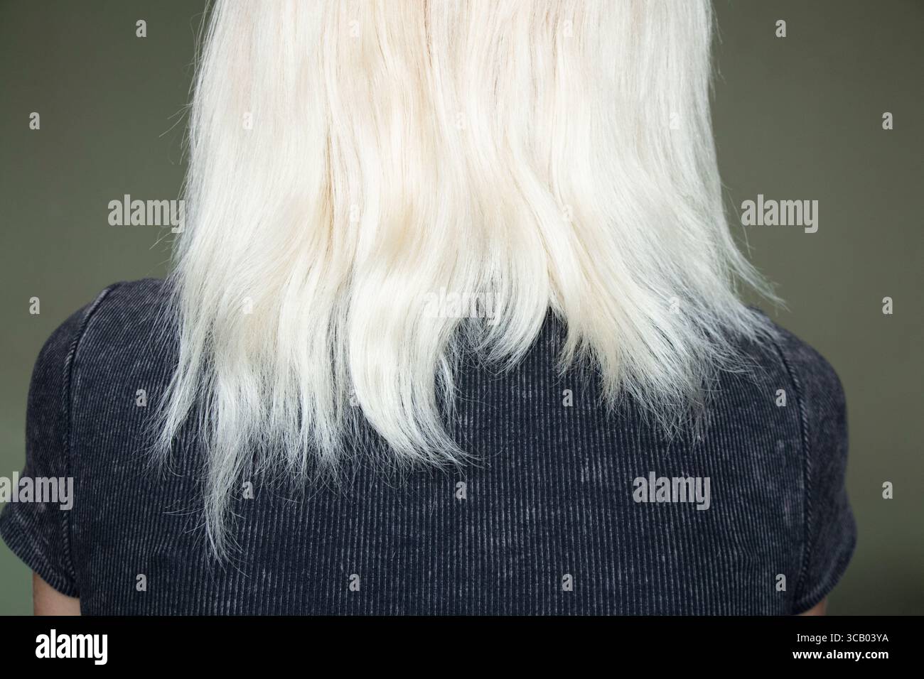 Capelli biondi secchi danneggiati di una ragazza da dietro, estremità fragili dopo la tintura, la cura e il trattamento dei capelli, concetto di struttura danneggiata Foto Stock