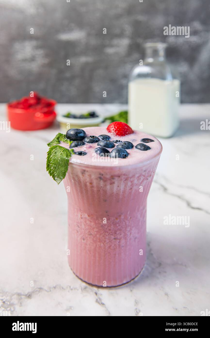 Bevanda antiossidante ai mirtilli: Un liquido viola intenso in un bicchiere alto, con ghiaccio tritato e una cosparsa di semi di chia per la crunch Foto Stock