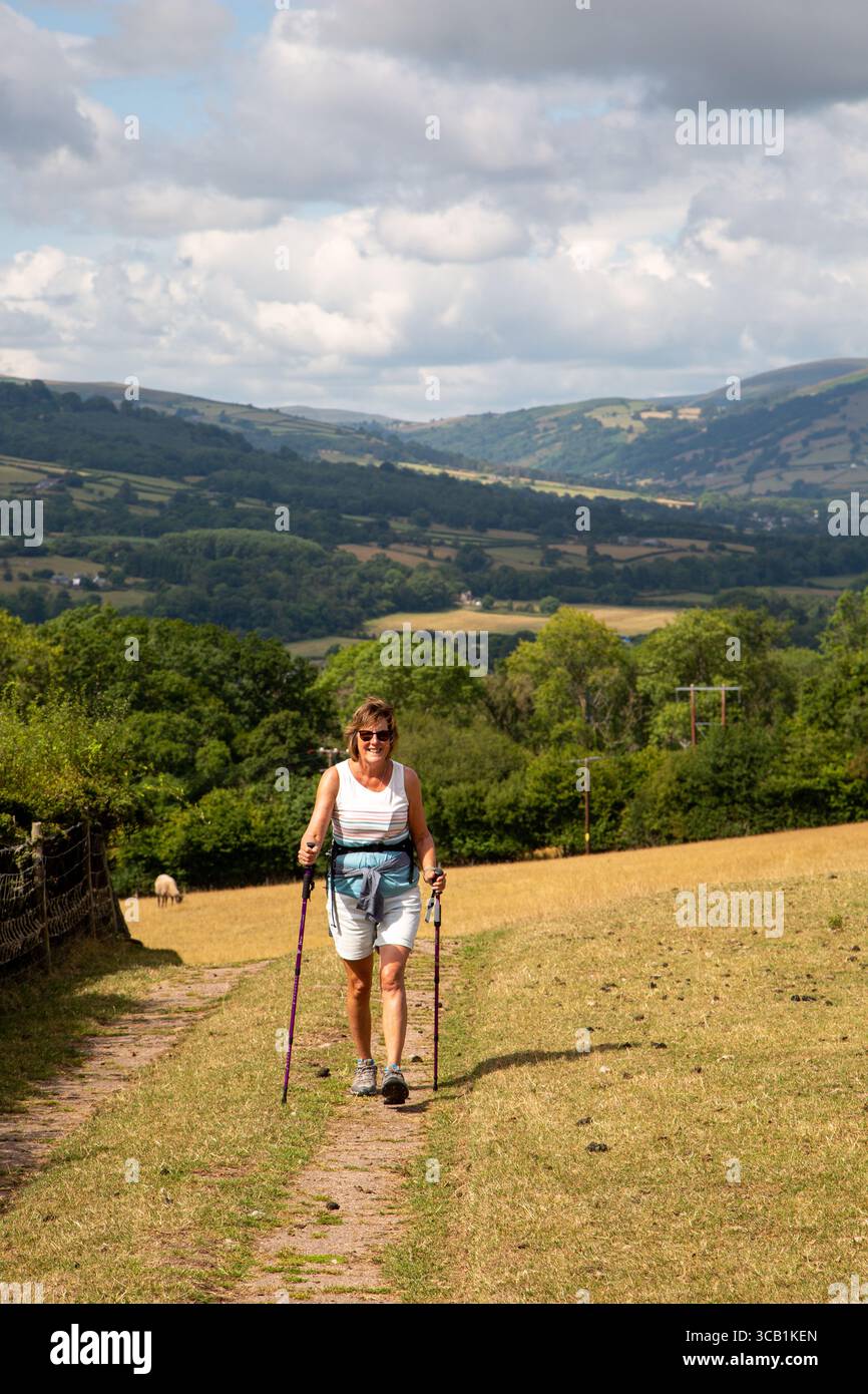 Donna che cammina nelle colline gallesi vicino a Crickhowell Powys, Galles, vicino ad Abergavenny con vista sulla valle di Usk Foto Stock
