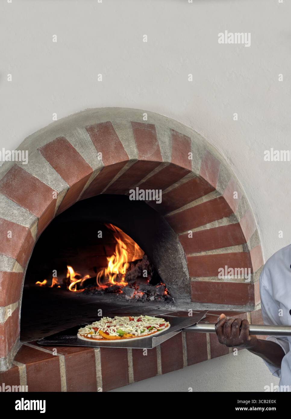Forno a legna per pizza. Un forno a legna per cucinare e cuocere la pizza. La pizza tradizionale italiana viene cucinata in un forno a legna in pietra. afroamericano Foto Stock Forno a legna per pizza. Un forno a legna per cucinare e cuocere la pizza. La pizza tradizionale italiana viene cucinata in un forno a legna in pietra. afroamericano Foto Stock