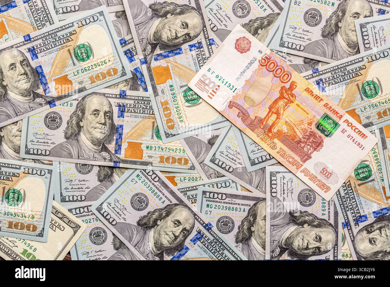 Un mucchio di cento dollari e 5000 rubli russi come sfondo finanziario Foto Stock