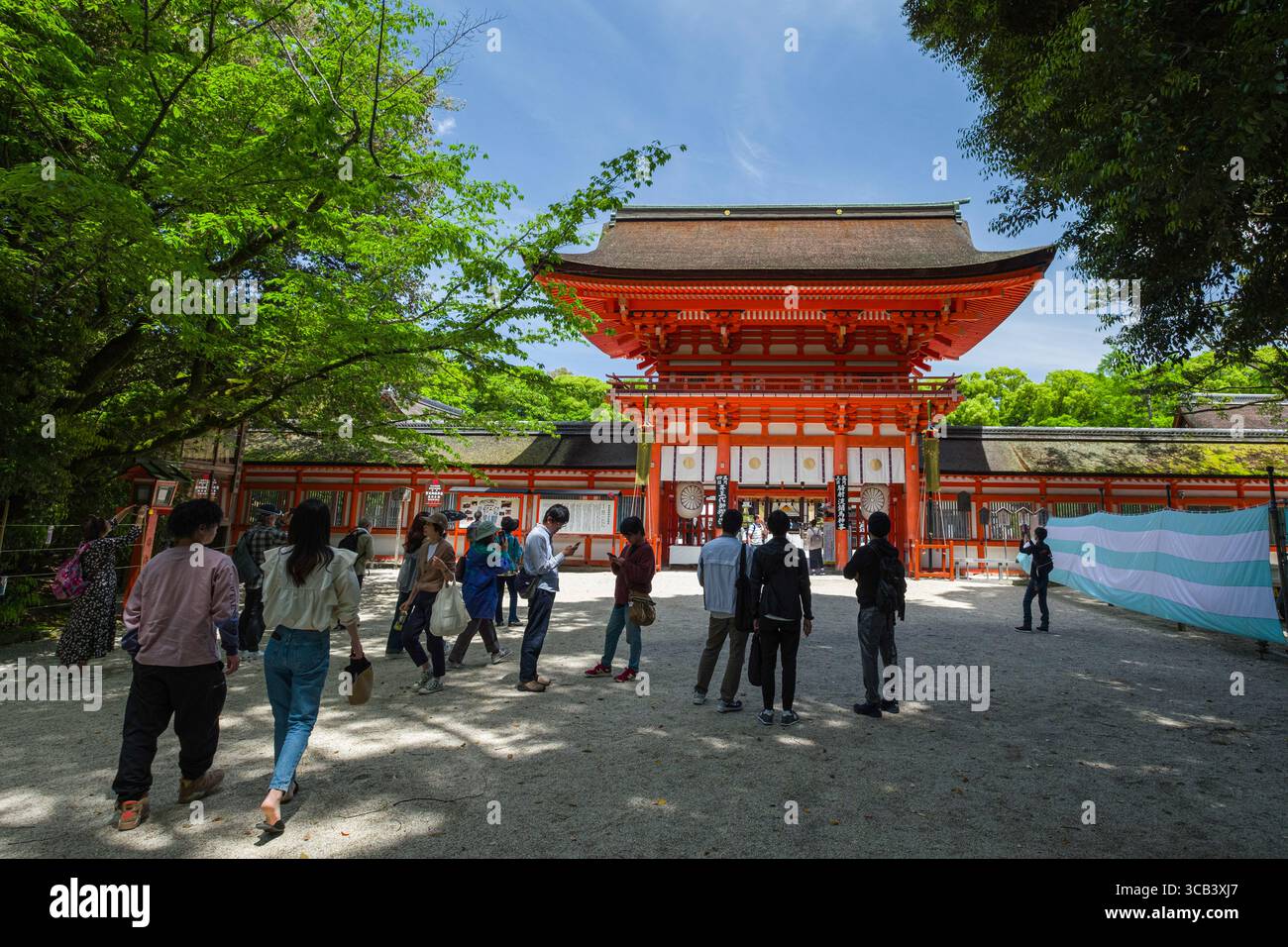 Un gruppo di visitatori esplora la porta della Torre Romon al Santuario Shimogamo-jinja durante il giorno, Kyoto, Giappone Foto Stock