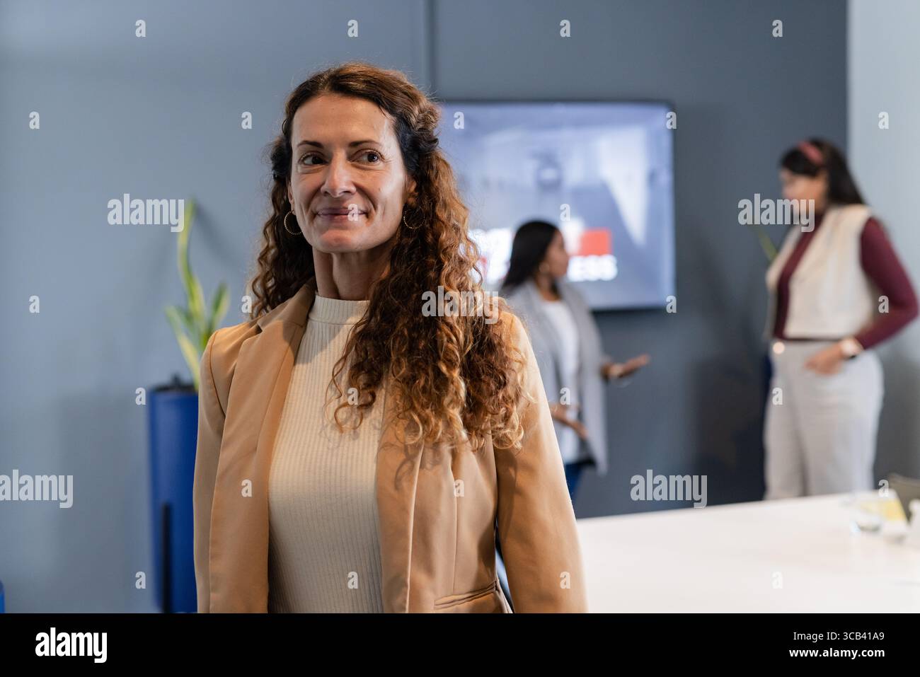 Diverse collaboratrici che discutono i dettagli del progetto nella moderna sala conferenze con monitor Foto Stock