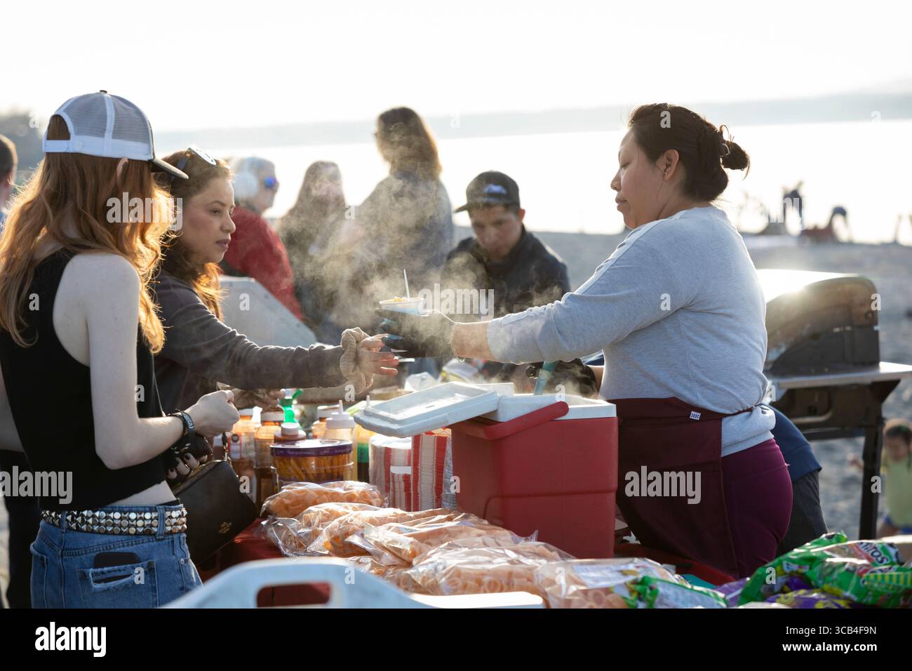 18 marzo 2023, Seattle, Washington, Stati Uniti: Un fornitore serve cibo messicano ai clienti che godono del caldo clima primaverile all'Alki Beach Park di Seattle sabato 18 marzo 2023. (Immagine di credito: © Paul Christian Gordon/ZUMA Press Wire) Foto Stock