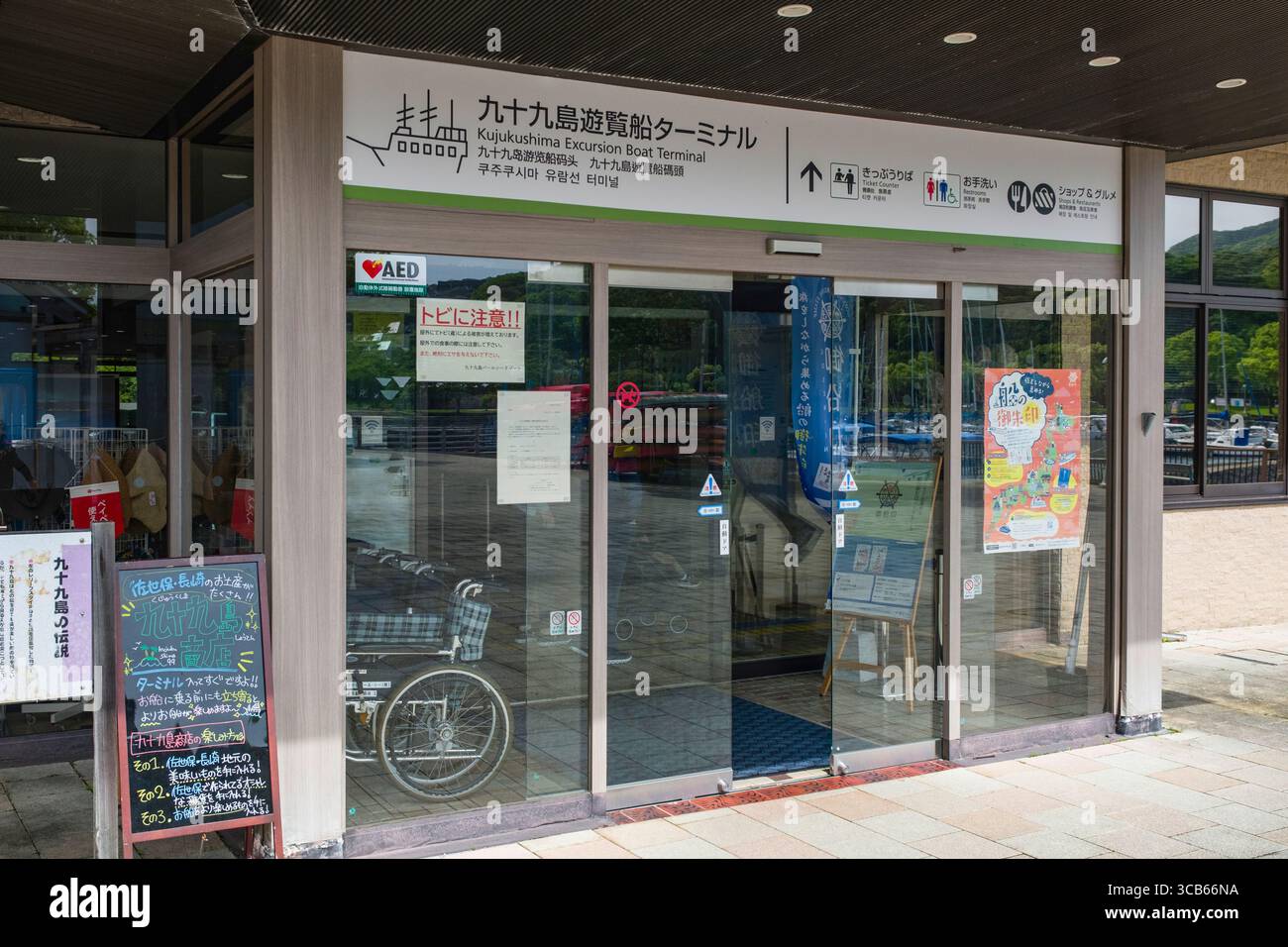 L'ingresso al terminal delle barche di Kujukushima Excursion in Giappone, che mostra insegne e porte di vetro, Sasebo, Giappone Foto Stock