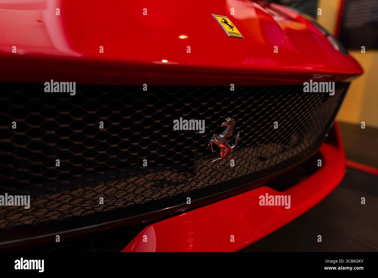 Primo piano della griglia a cavalletto Ferrari e cappuccio rosso al Museo Ferrari di Maranello, simbolo della velocità, del lusso e dell'eccellenza del design italiani Foto Stock