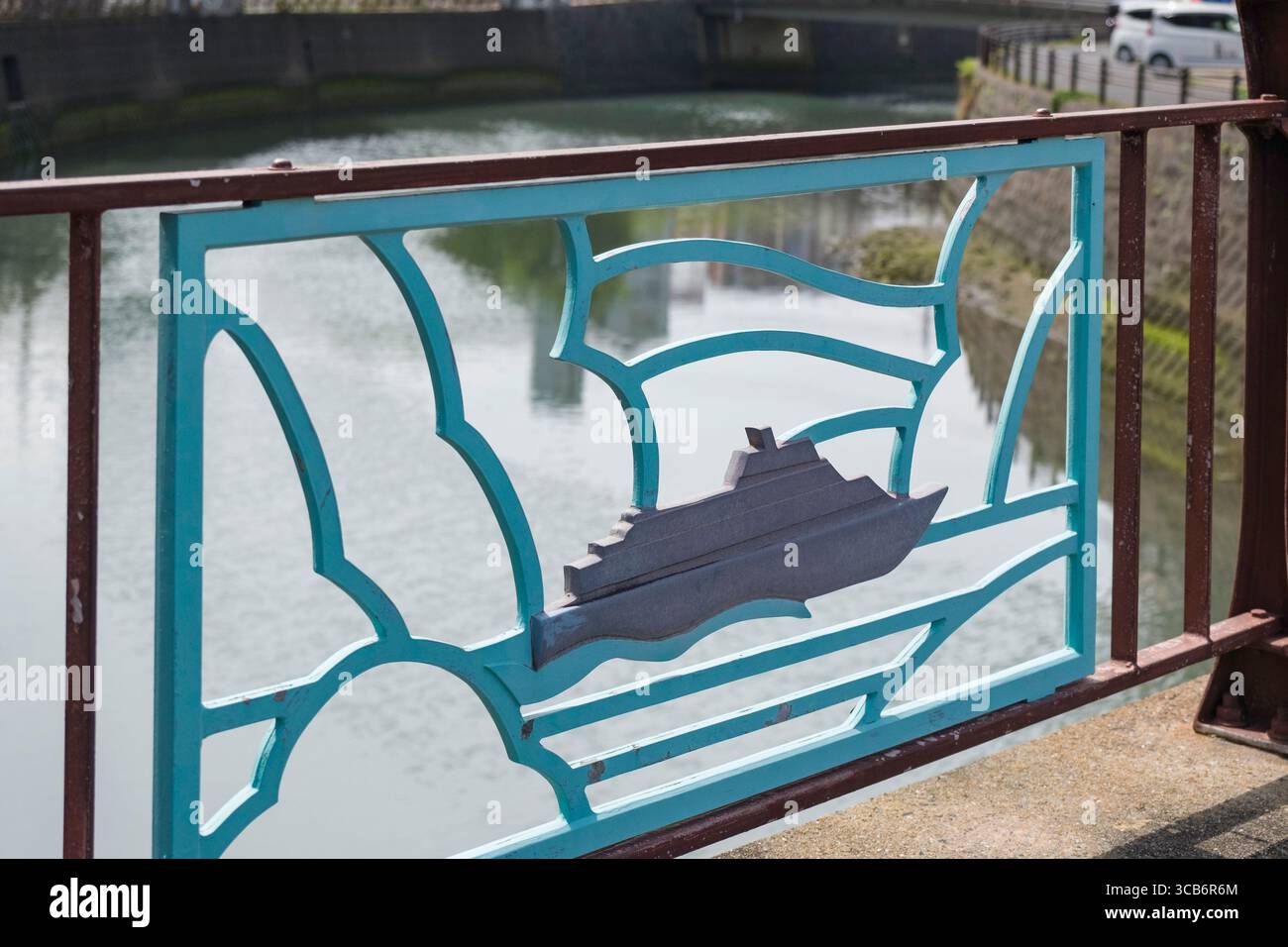Una vivace ringhiera in metallo su un ponte che mostra il design di una nave, con il fiume Sasebo sullo sfondo, Sasebo, Giappone Foto Stock
