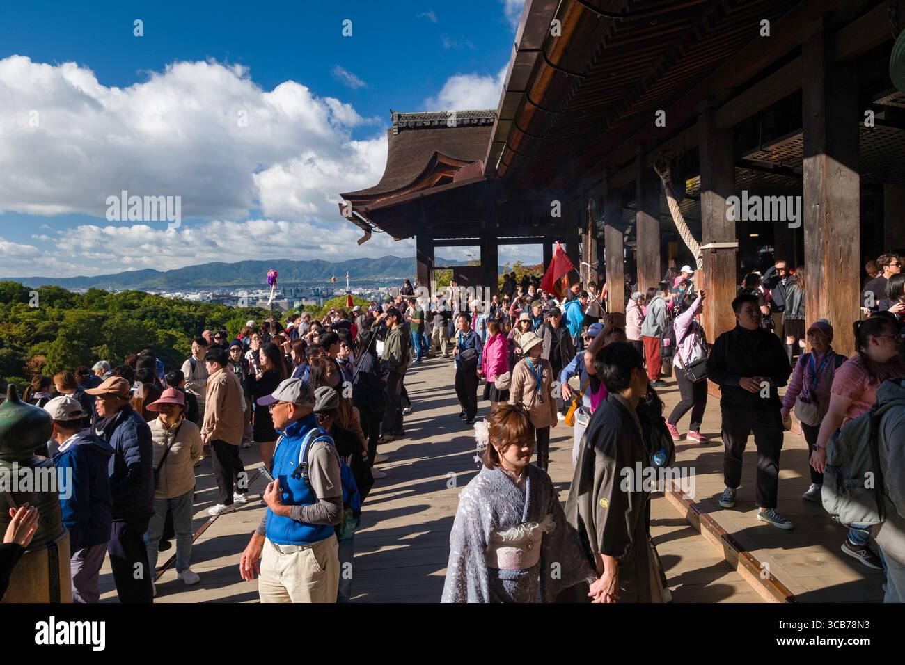I turisti esplorano l'iconico palcoscenico del tempio buddista Kiyomizu-dera tra cieli limpidi e viste panoramiche, mostrando apprezzamento culturale Foto Stock