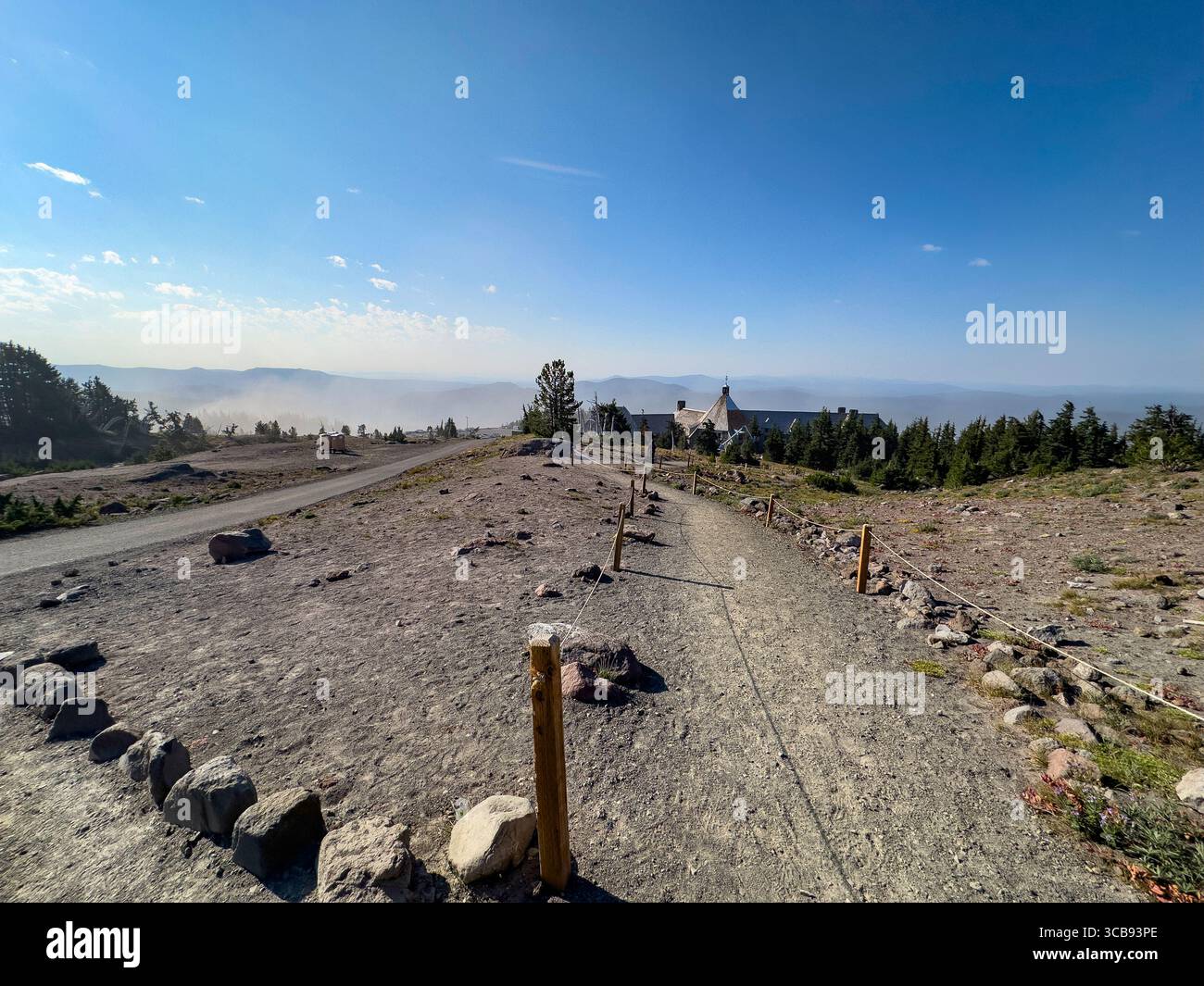 Un sentiero sterrato panoramico circondato da un paesaggio montano conduce a un remoto Timberline Lodge, Mount Hood, Mount Hood National Forest, Oregon, Stati Uniti Foto Stock
