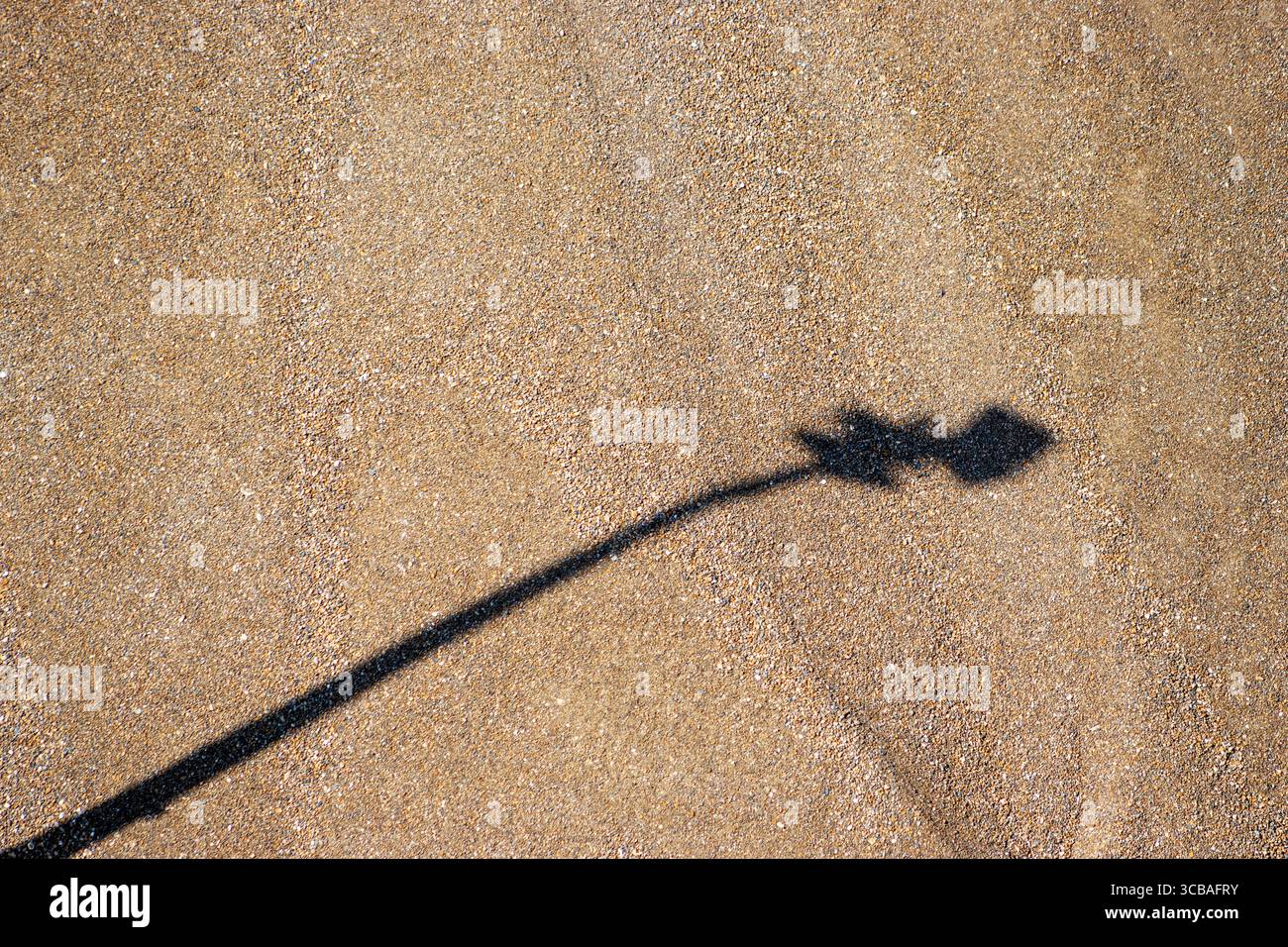 ombra di una luce di sicurezza con sfondo di ghiaia marrone grigia Foto Stock