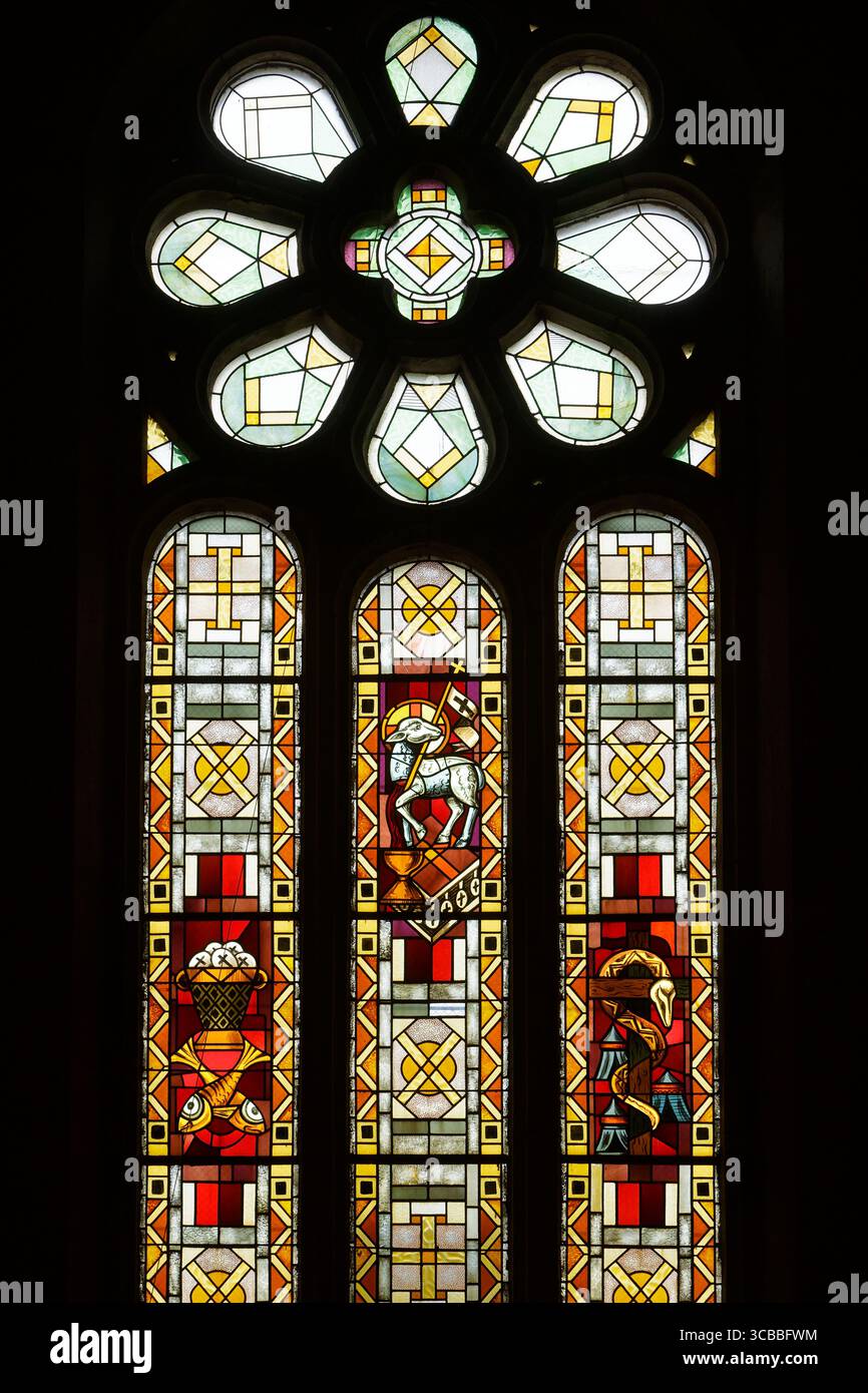 Francia, Meurthe et Moselle, Fenneviller, villaggio ha ricevuto due volte la Croce di guerra per i danni subiti durante la prima e la seconda guerra mondiale, chiesa della Natività della Vergine distrutta durante la prima guerra mondiale nel 1915, ricostruita in stile neogotico dall'architetto Nancy Georges Biet e dall'appaltatore Masson nel 1925, vetrata in stile Art Deco realizzata nel 1925 dal maestro vetraio di Nancy Georges Janin che rappresenta da sinistra a destra la moltiplicazione di pane e pesci, l'agnello di Dio e il serpente di bronzo Foto Stock