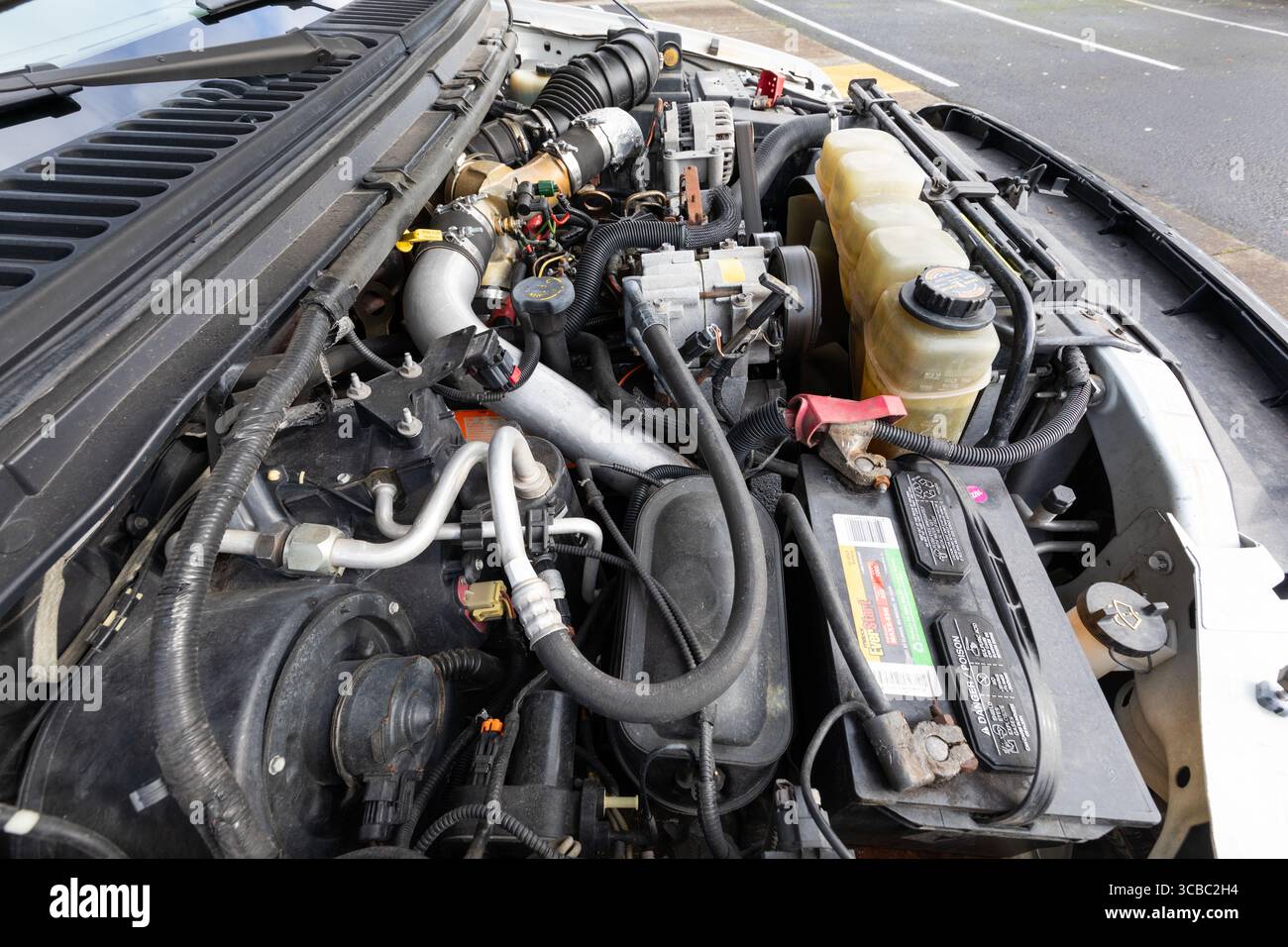 Portland, Oregon-USA-23 gennaio 2024-2000 White Ford F-250 XLT Super Duty Power Stroke Diesel V8 motore americano per pick-up, batteria, sistema di aspirazione dell'aria Foto Stock
