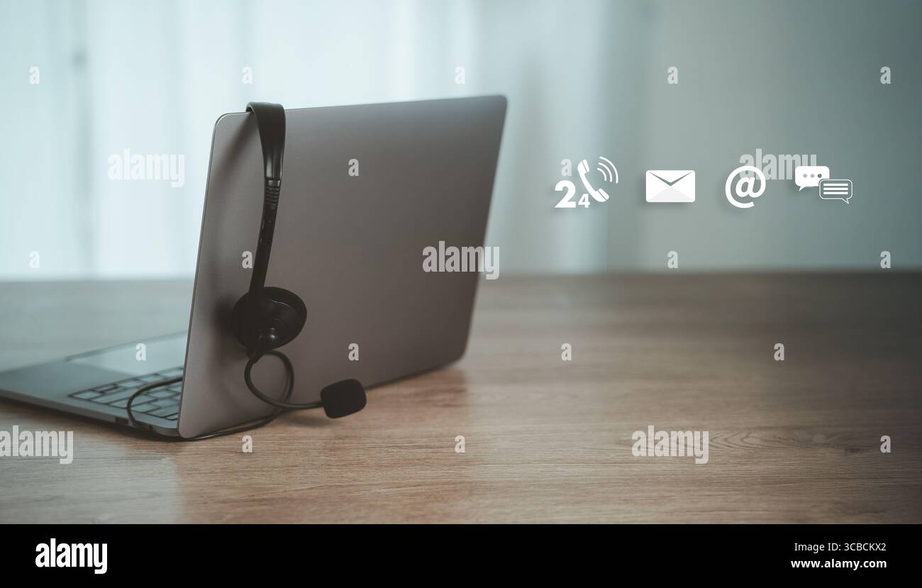 Computer portatile con cuffie e icone di contatto, tra cui telefono, e-mail, AT Symbol e chat, che rappresentano il servizio clienti, comunicazione online e multi-chan Foto Stock