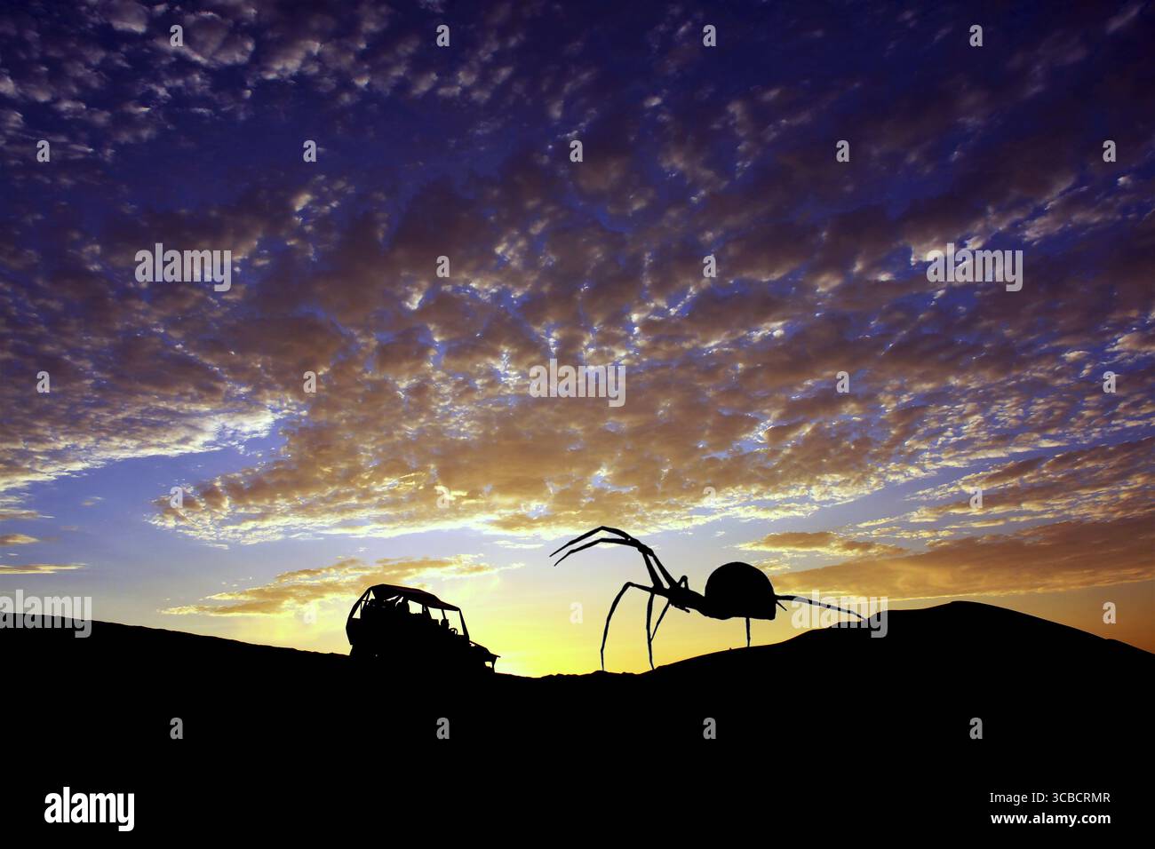 La silhouette di un ragno gigante davanti a un buggy Foto Stock