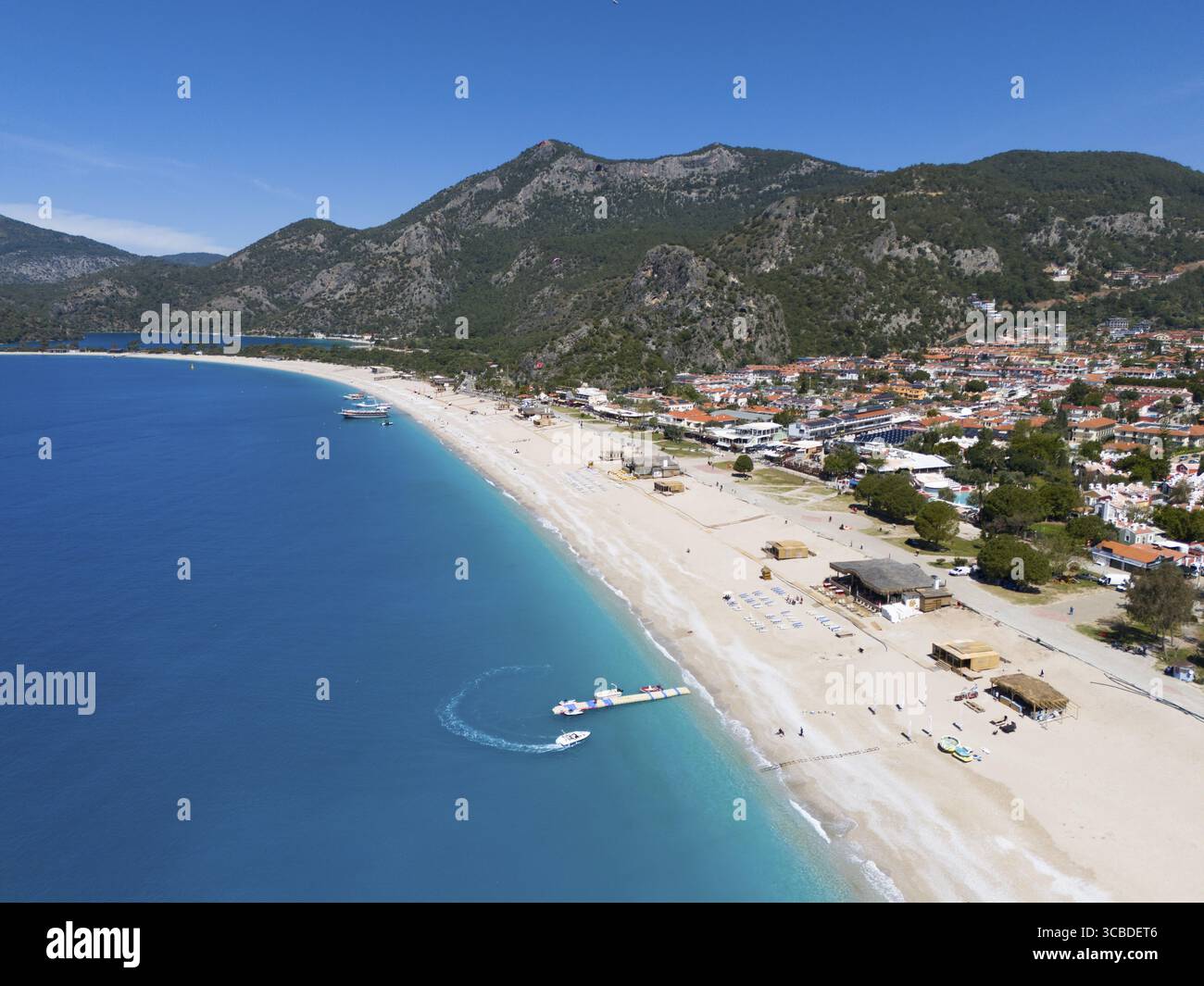 Veduta aerea di una lunga spiaggia sabbiosa con la città vicina e lo sfondo montuoso, veduta aerea, Fethiye, Mugla, Mugla, Mar Egeo, Turchia Foto Stock