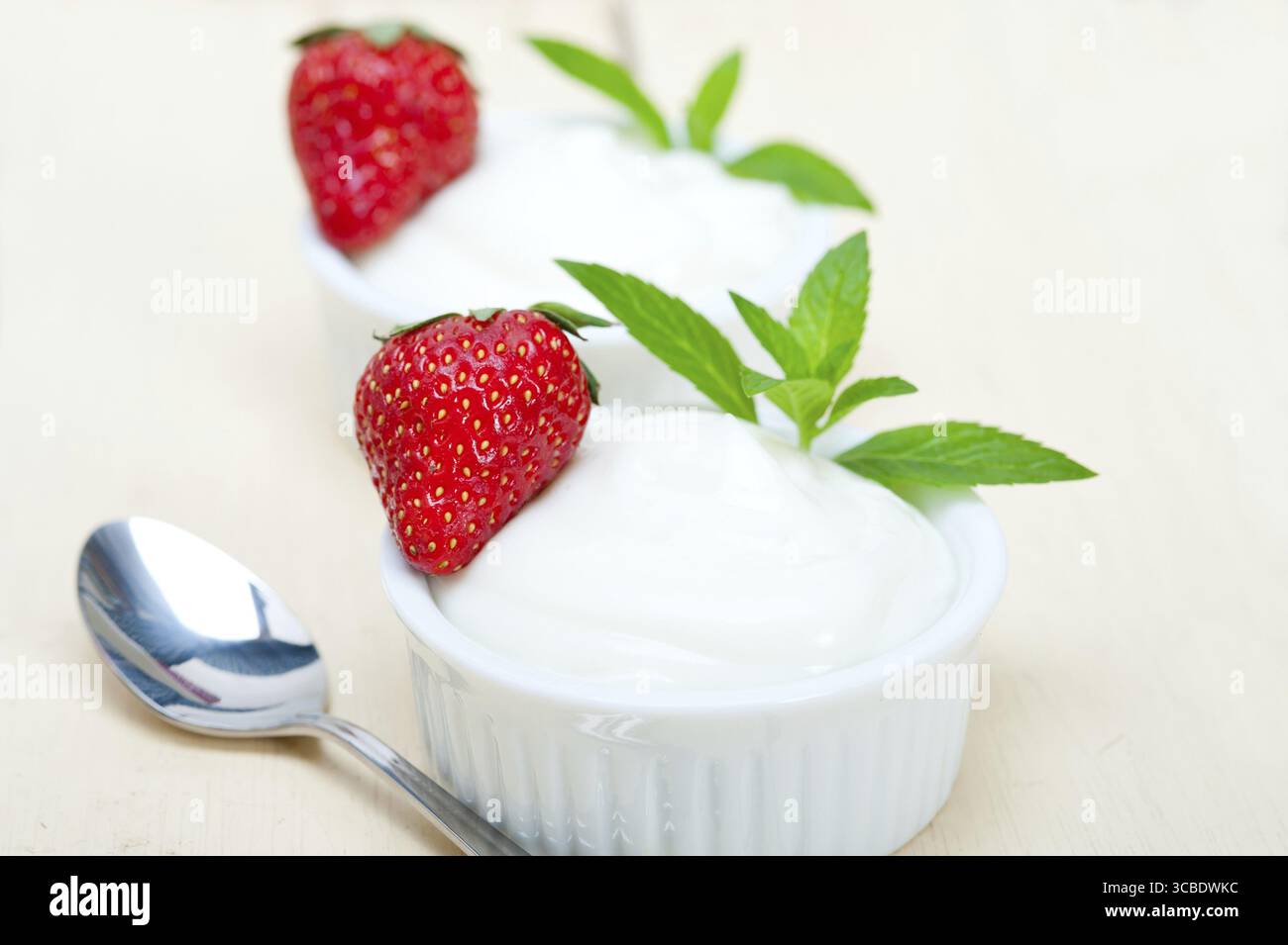 Yogurt greco biologico e fragola su tavola di legno rustico bianco Foto Stock