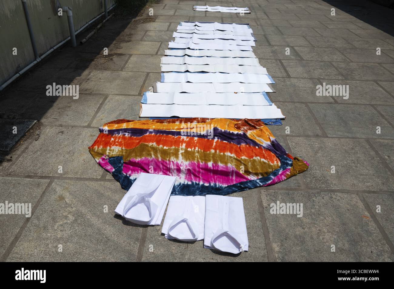 Vestiti distesi sul marciapiede per asciugare, lo stile di vita e la cultura dell'India, lavanderia dhobi ghat a Kochi, Asia Foto Stock