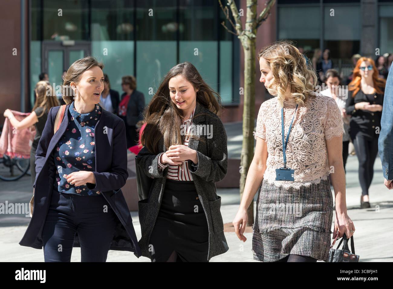 Tre donne professionisti che camminano e parlano durante la pausa pranzo nel centro di Liverpool in una giornata di sole. Foto Stock
