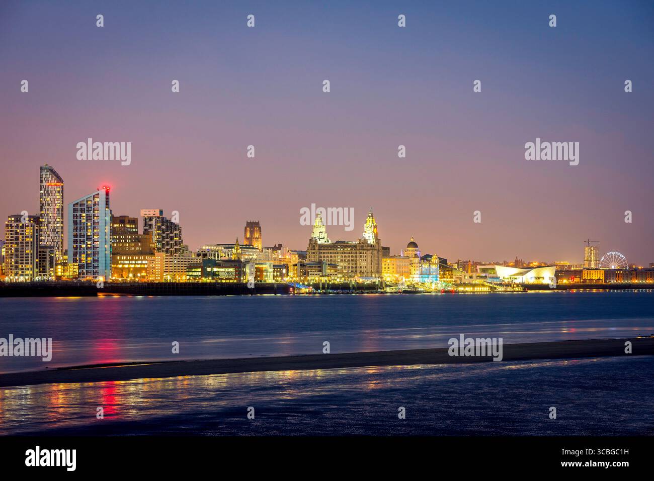 Skyline di Liverpool di notte con il lungomare illuminato e i riflessi sul fiume Mersey. Foto Stock