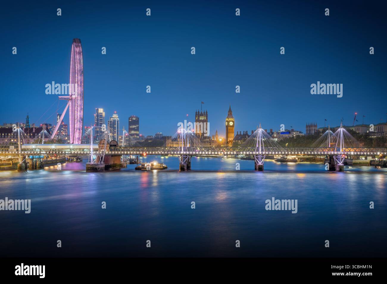 Splendida vista dell'ora blu dal Waterloo Bridge di Londra, con Big Ben, Westminster Palace e il London Eye illuminati contro il cielo crepuscolo. Foto Stock