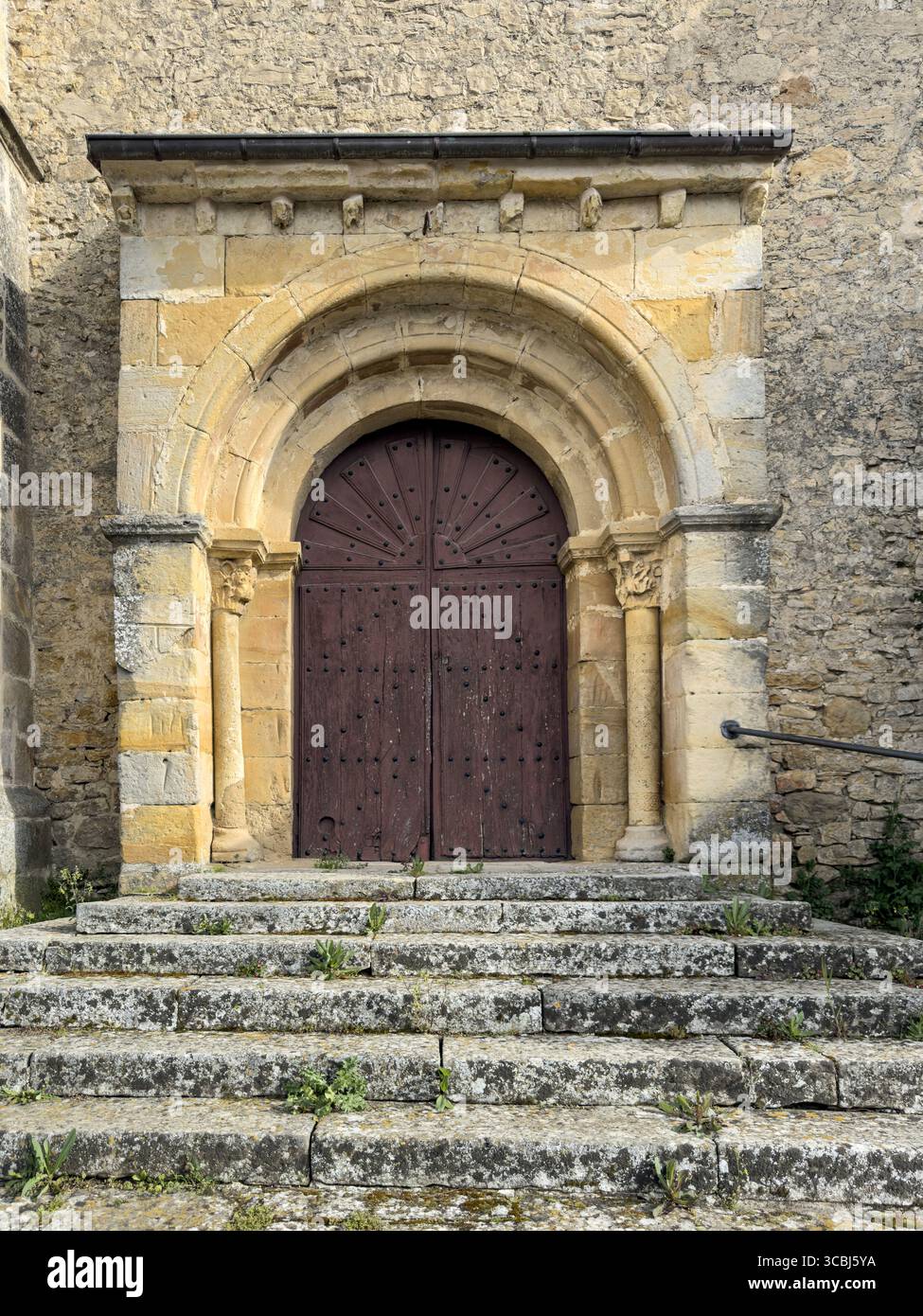 Porta storica della chiesa romanica con arco e scale in pietra nella Spagna rurale Foto Stock